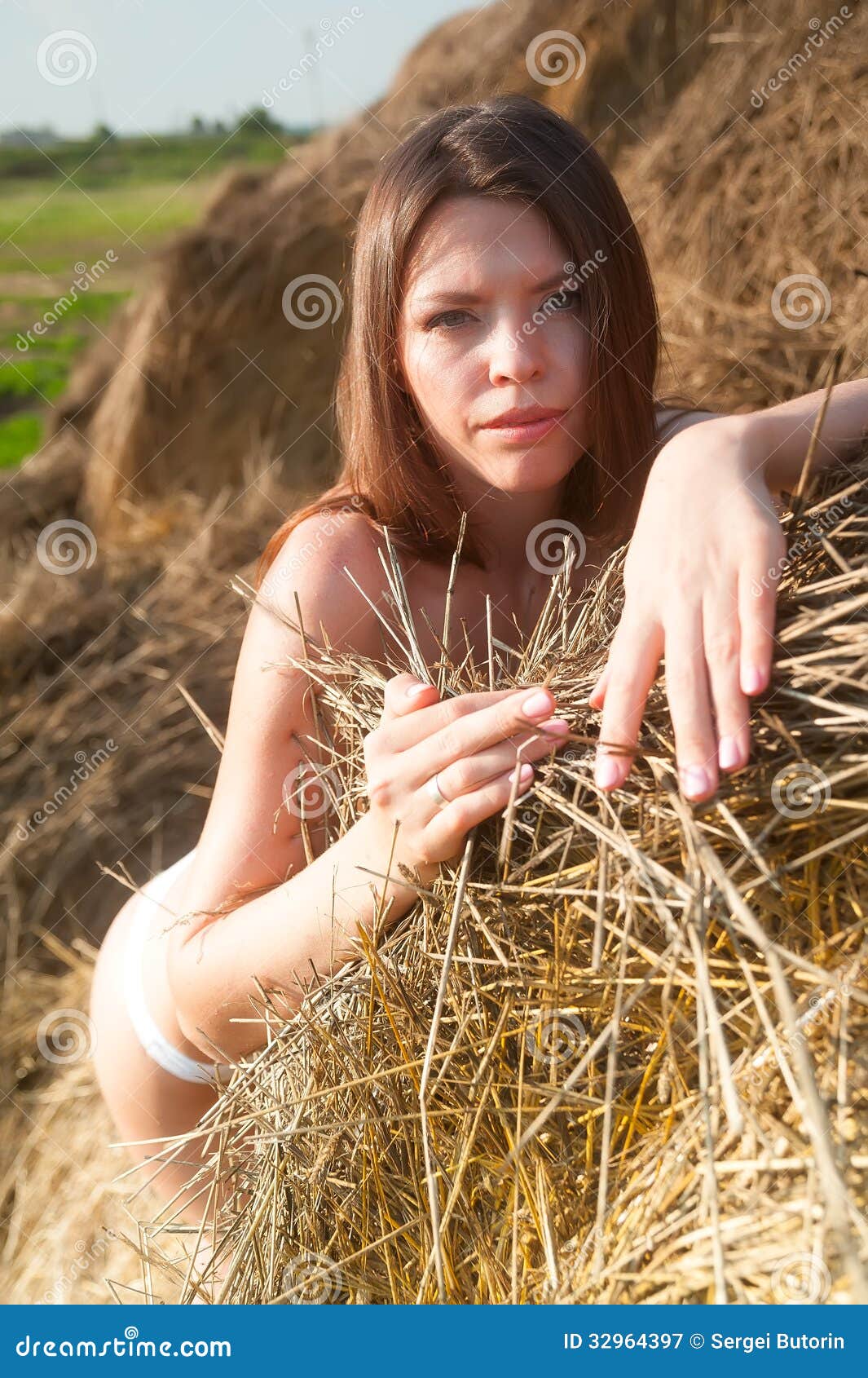 Pretty woman lying on straw. Beautiful young cowgirl with 
