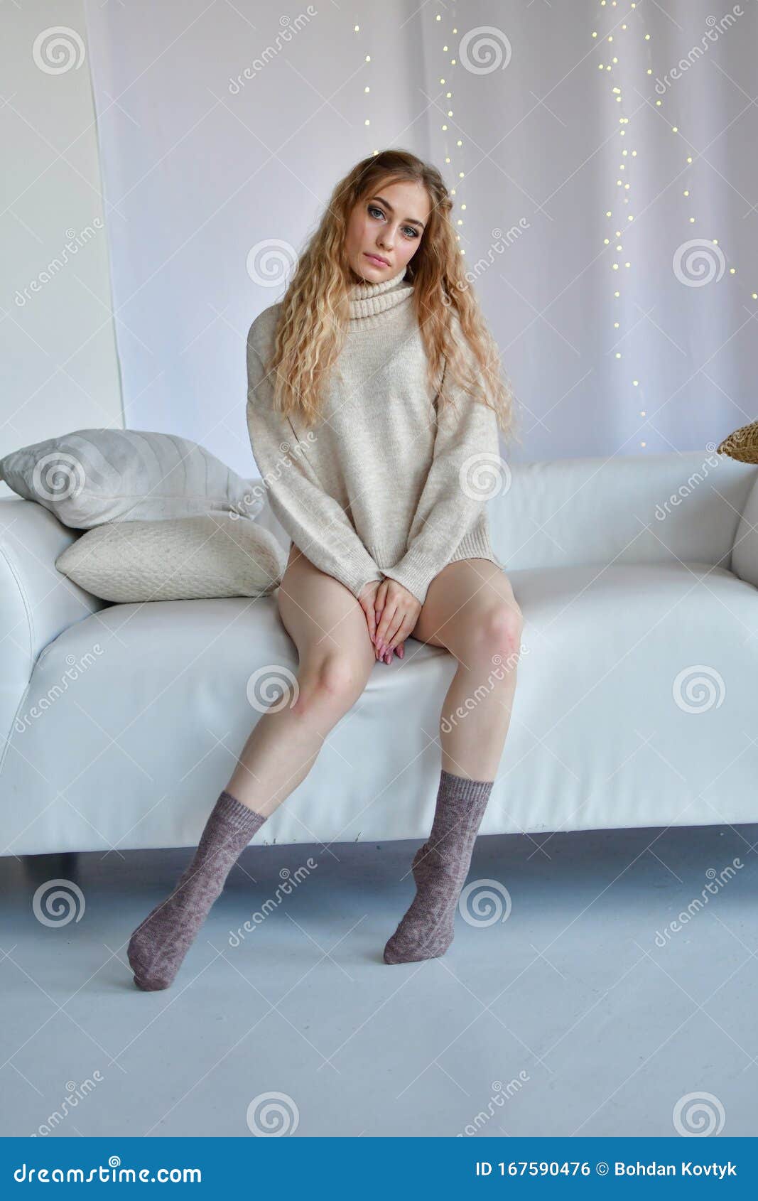 Girl Sits In Erotic Poses With Legs Wide Apart On Sofa In Sweaters And