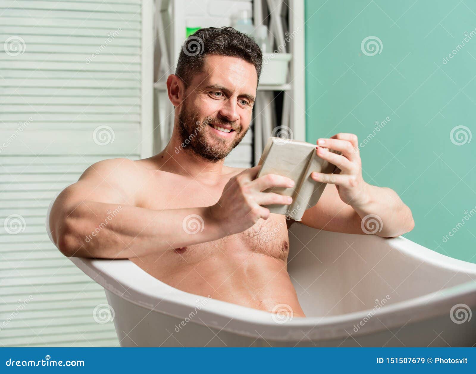 Man in Bathroom Reading. Macho Naked in Bathtub picture