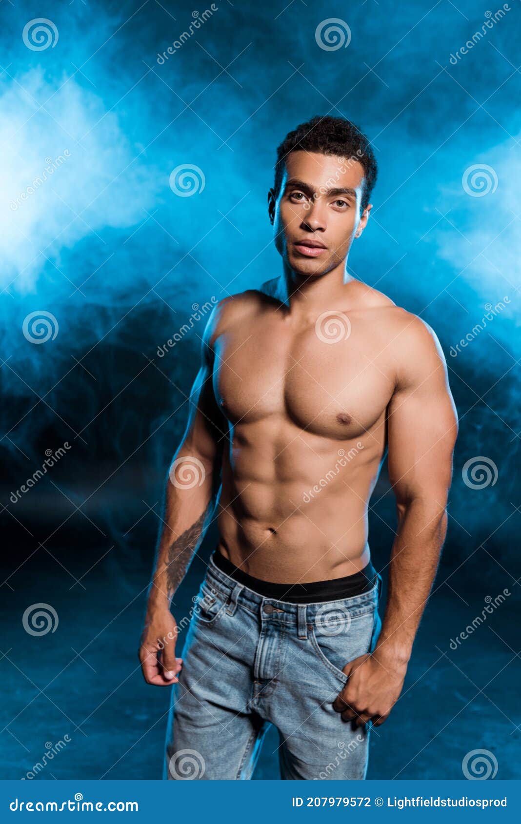 Shirtless Man Hugging Young Woman Standing in Lace Bra on Blue