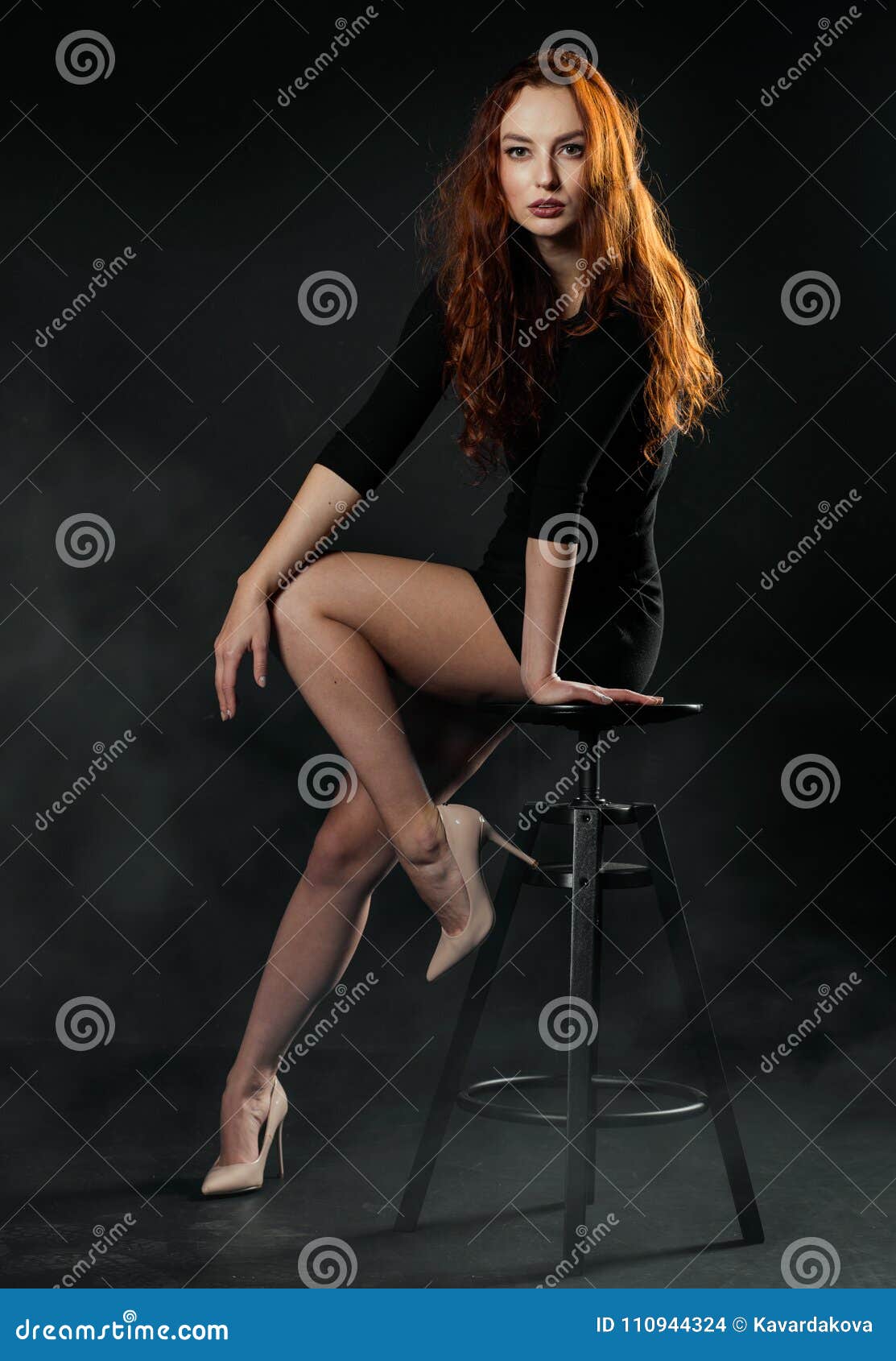 Positive young female model in sportsclothes rides on blades enjoys leisure  activities poses at urban place against blurred background stands in full  length. Active lifestyle and rollerblading concept - a Royalty Free