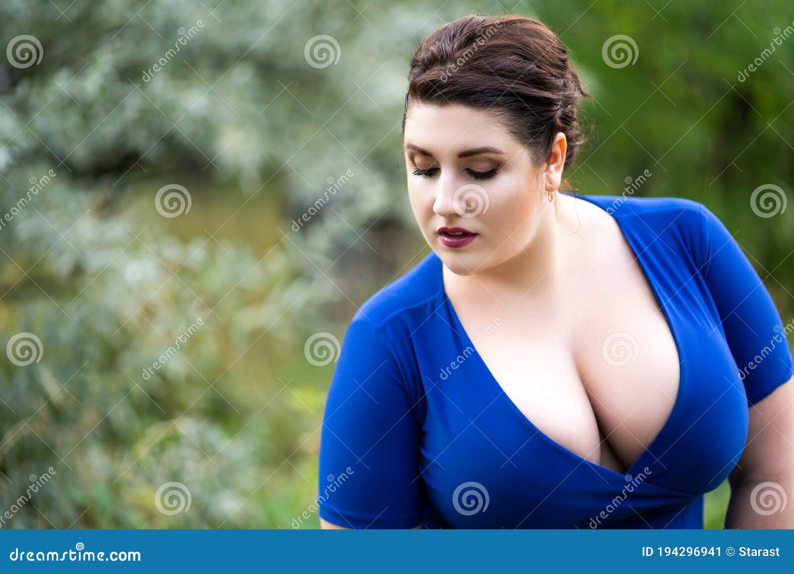 Plus Size Fashion Model in Blue Dress with a Deep Neckline