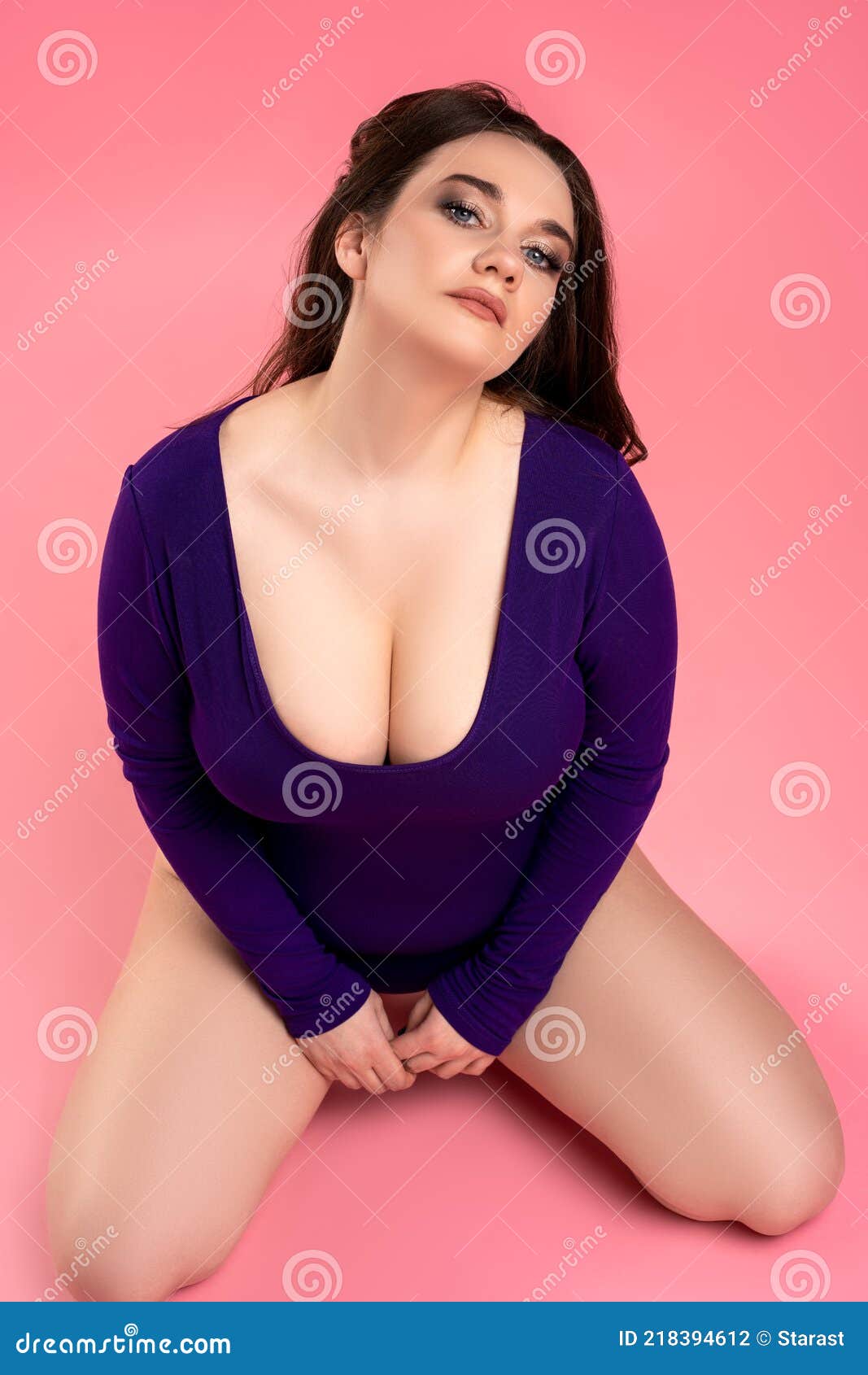 Plus Size Model with Large Breasts in Purple Bodysuit on Pink
