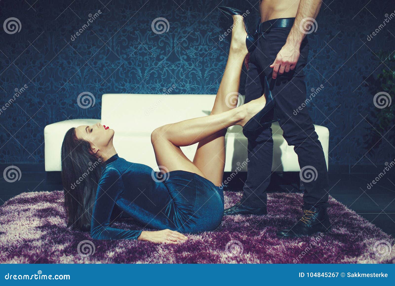 Sensual Woman on Carpet Playing on Man Abs by Her High Heel Stock Image