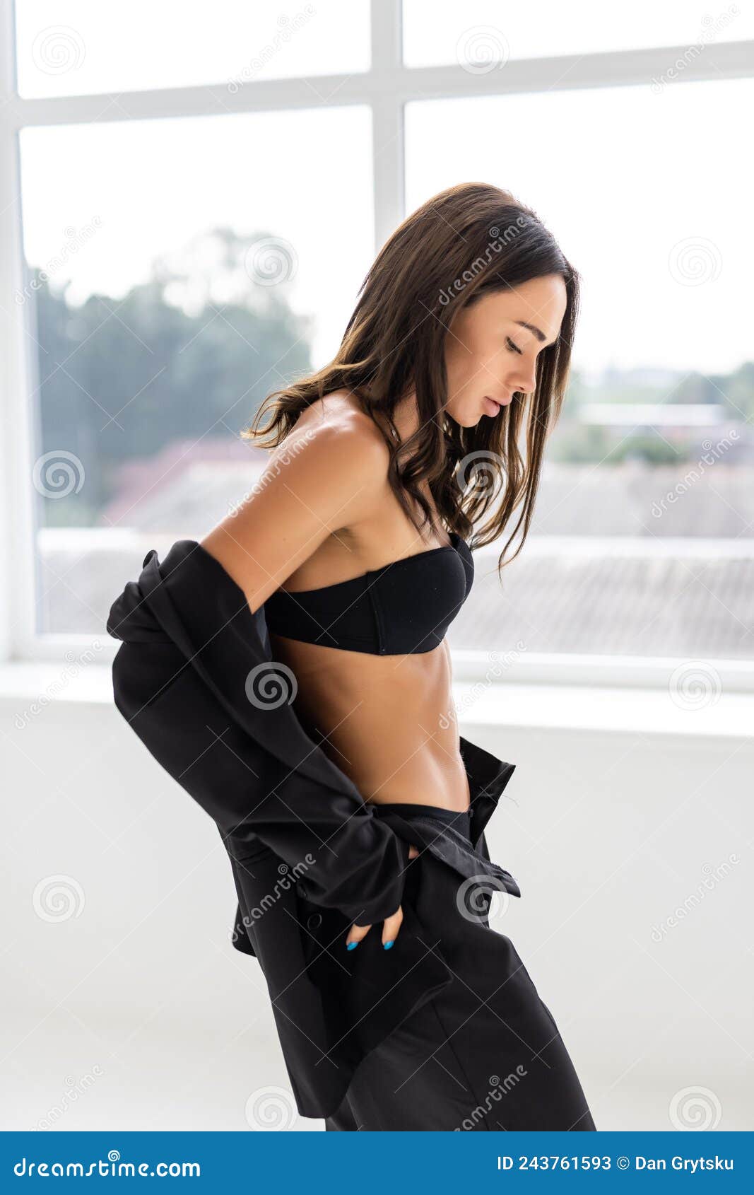 Slim Brunette Woman Wearing Fashionable Black Suit with No Bra is