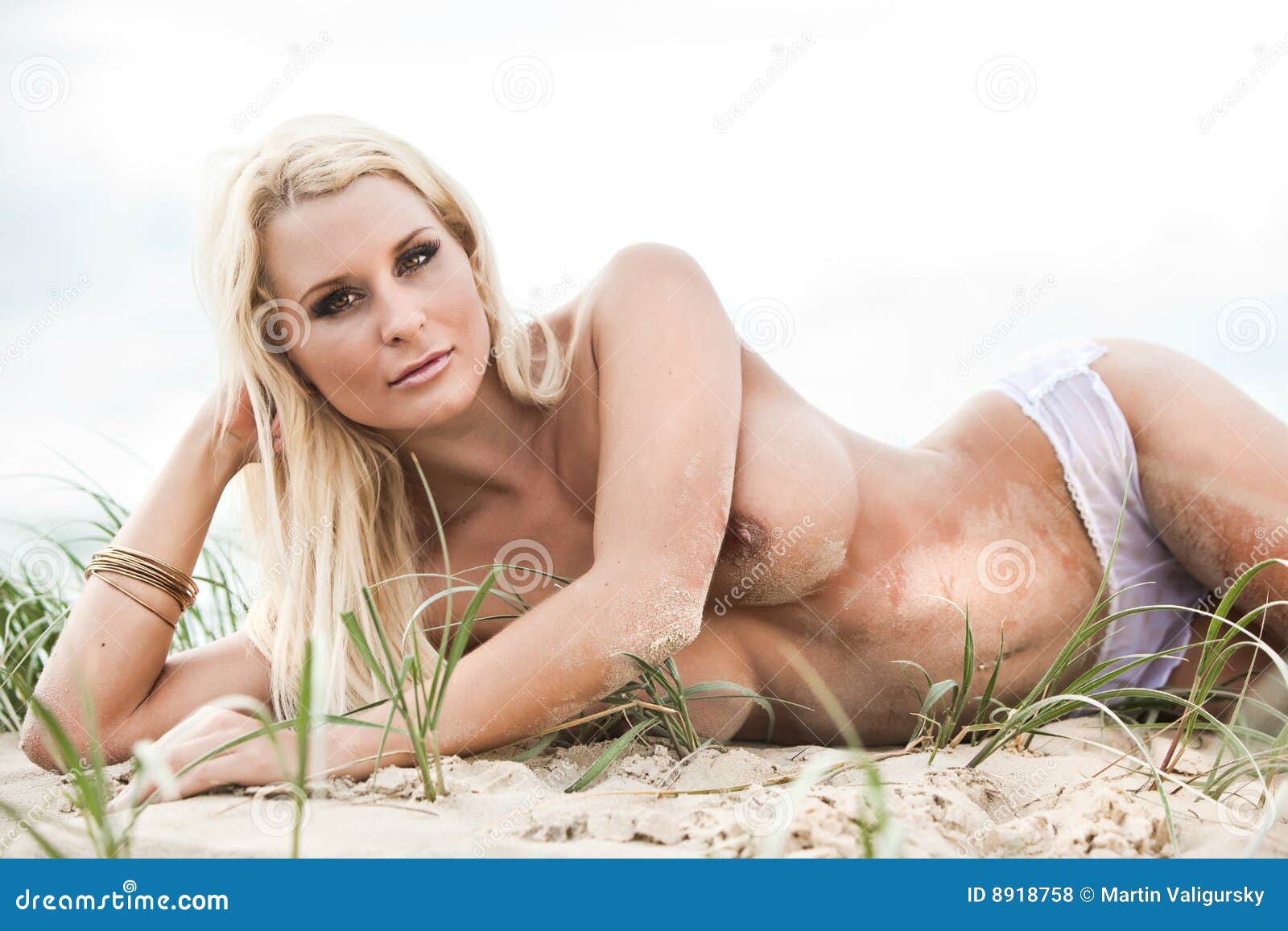 Stor kvinna på stranden för topless älskare