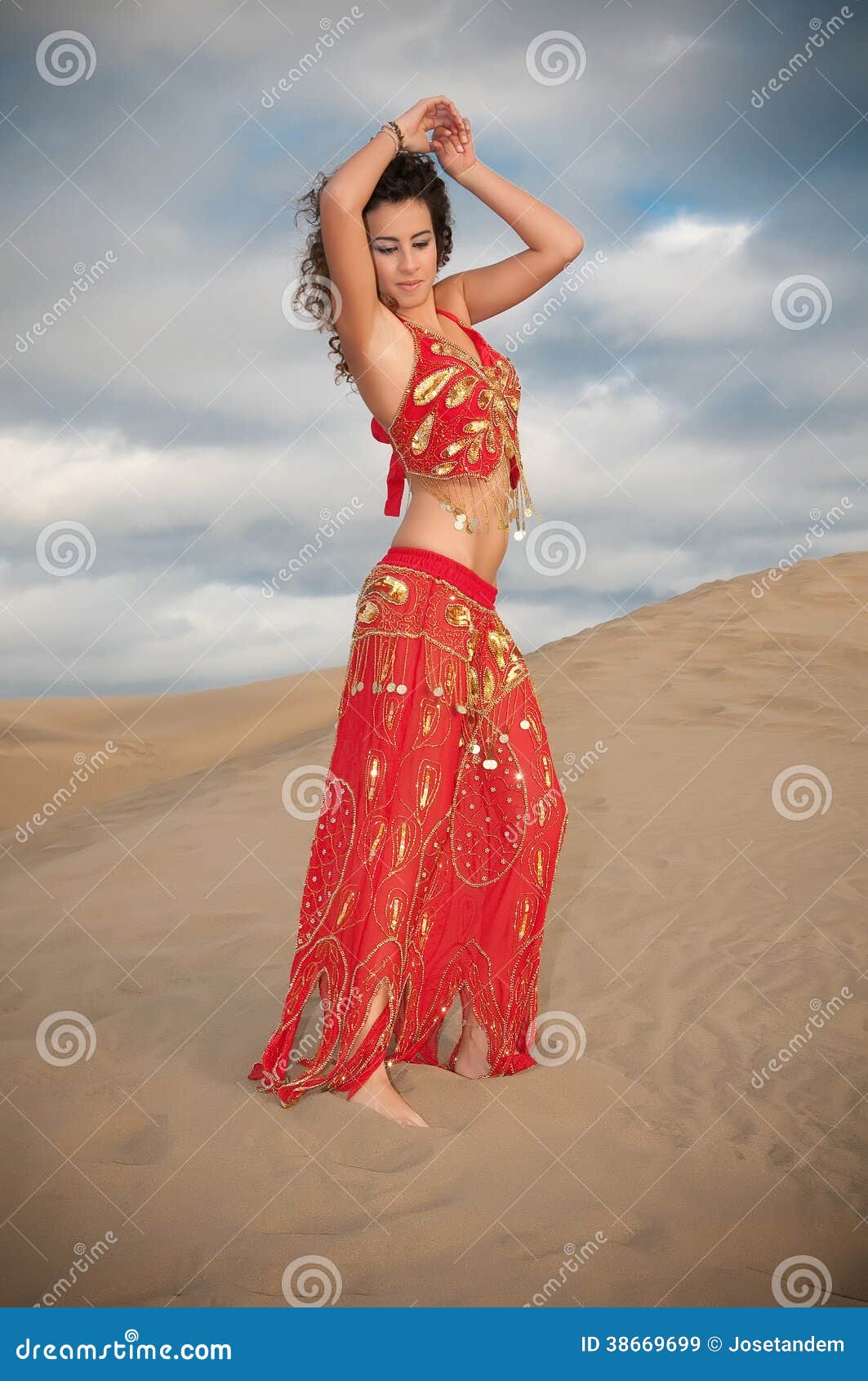 woman belly dancer arabian in desert dunes at the afternoon