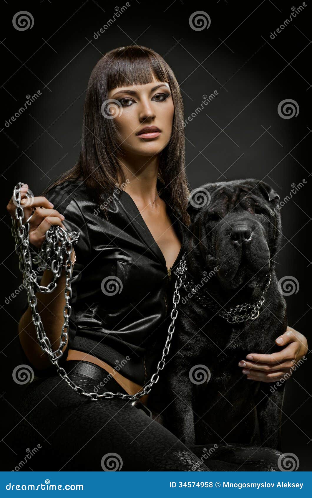 woman with dog. The beautiful young woman sit with dog on black background