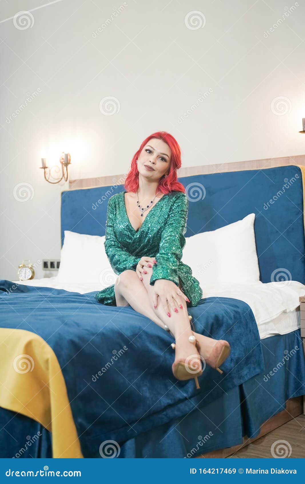 sexy woman in green stylish sparkling glitter dress ready for christmas party and relaz by waiting in her bed alone
