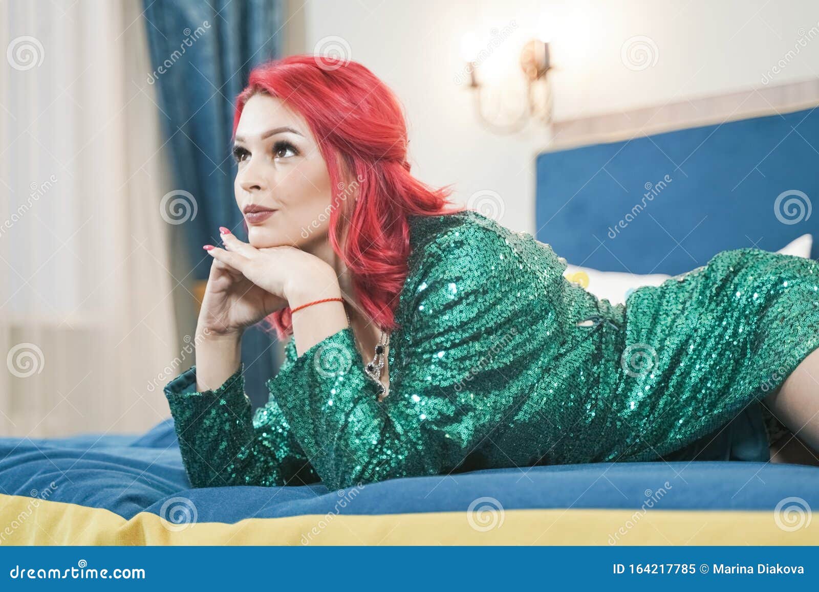 sexy woman in green stylish sparkling glitter dress ready for christmas party and relaz by waiting in her bed alone
