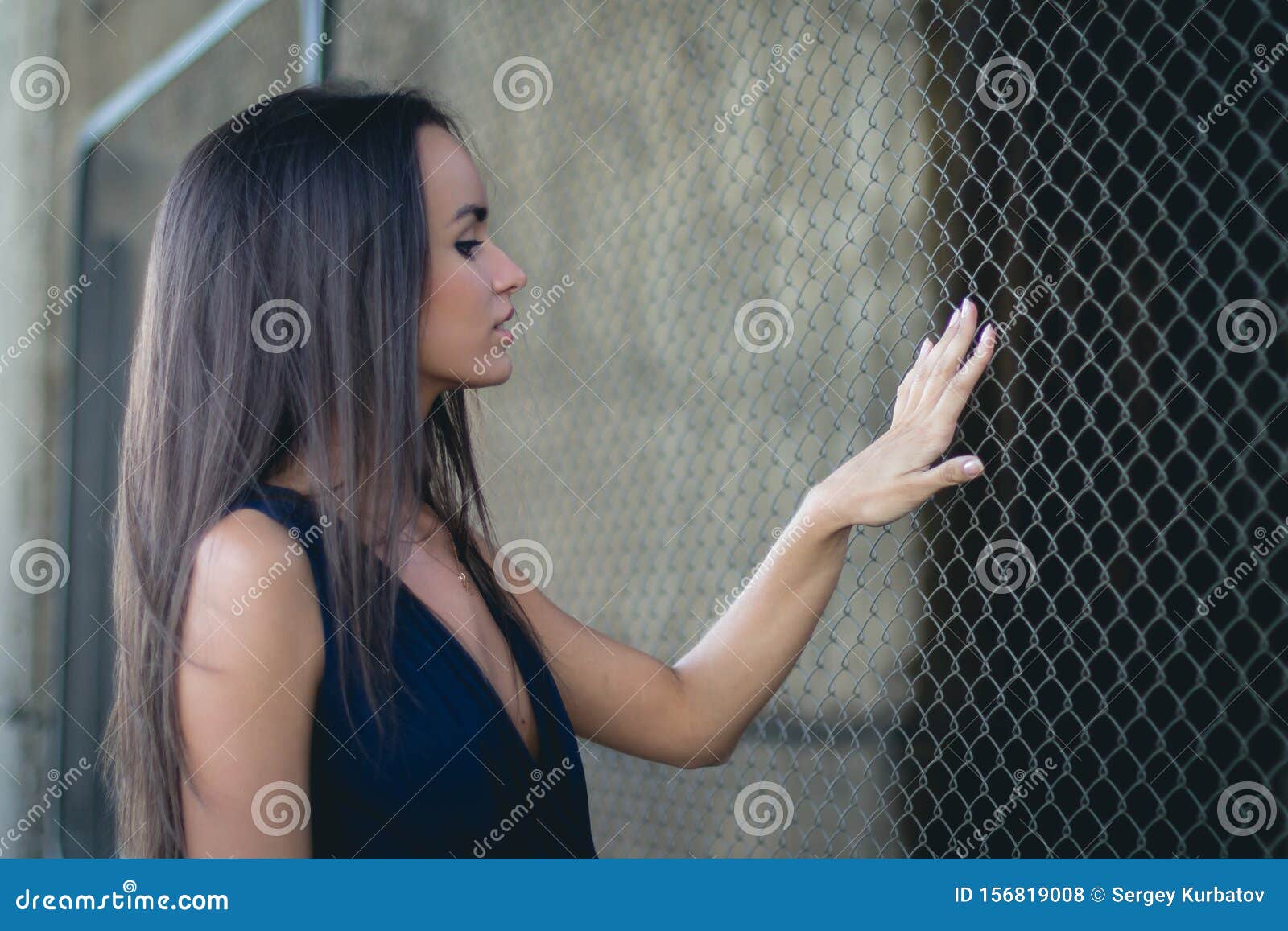 Young Beauty Woman Posing Over Metal Fence Background Stock Photo