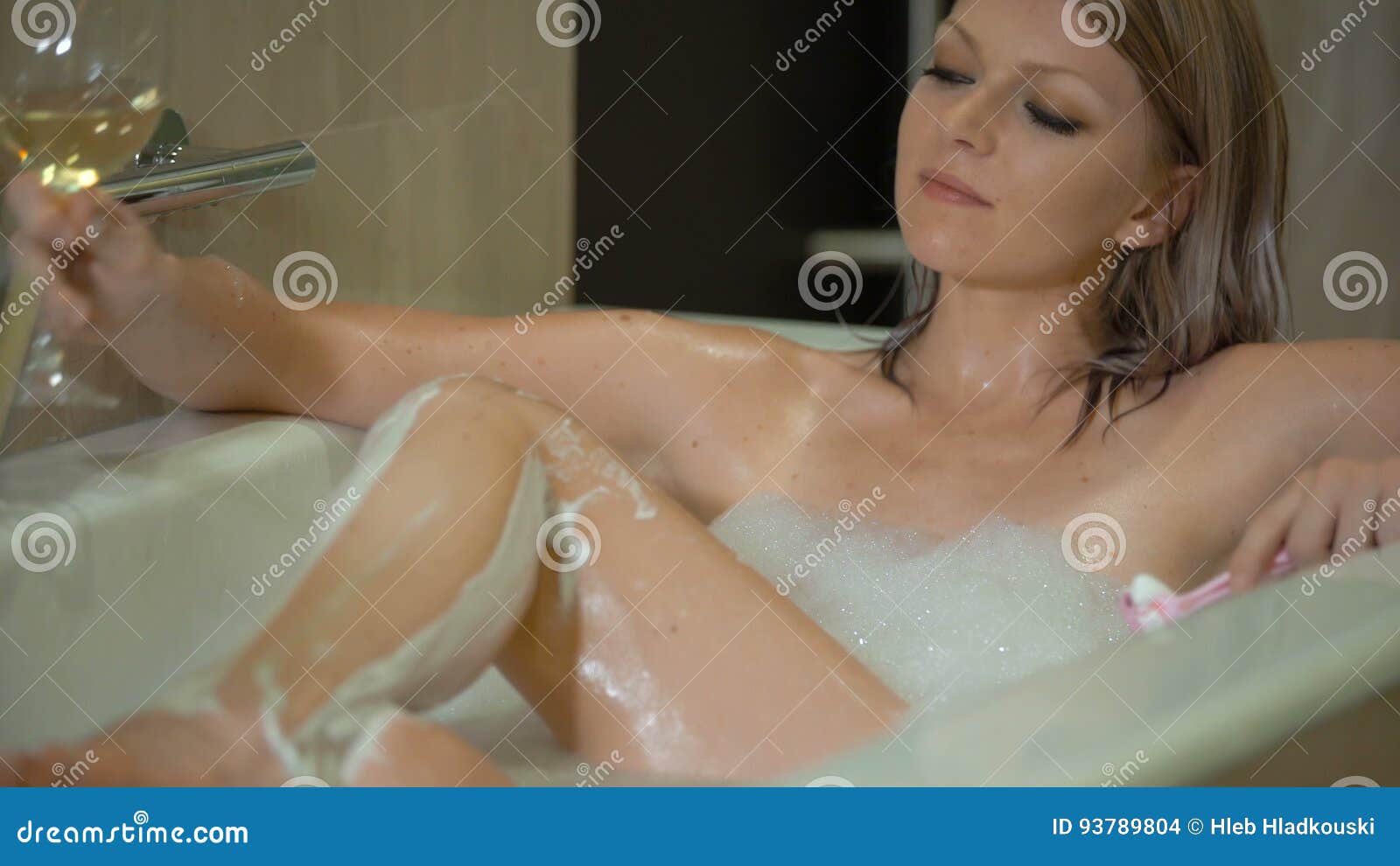 Brunette babe smoking while soaking into the bathtub
