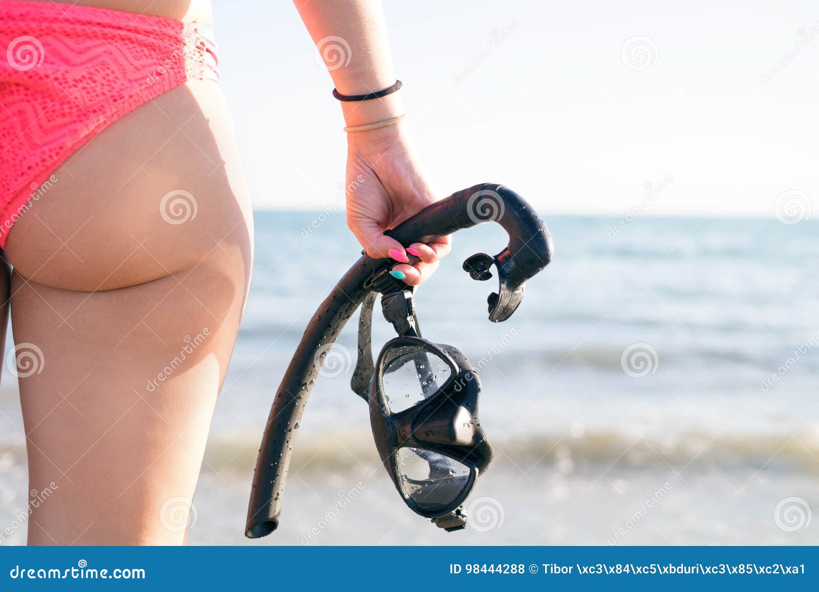 Young Woman Buttocks with Snorkel and Masks on a Sandy Beach. Water