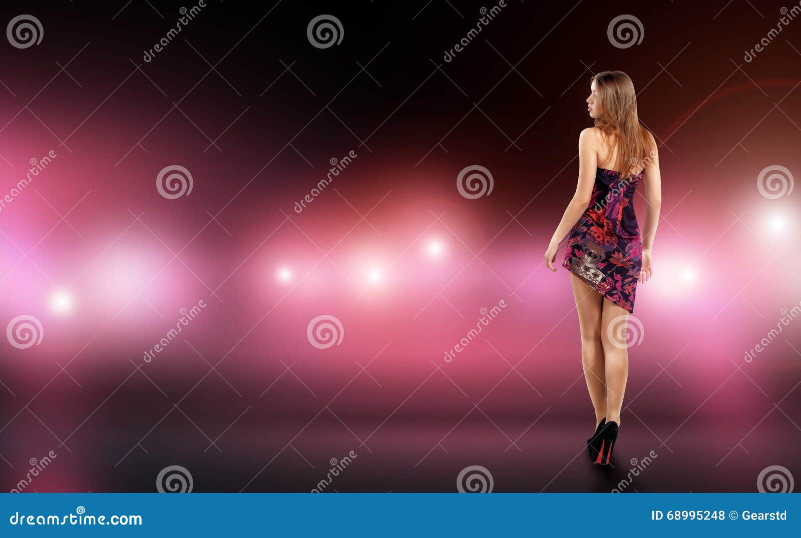 young woman in fitting dress is surrounded by care and camera flash. Celebrity, model, star.