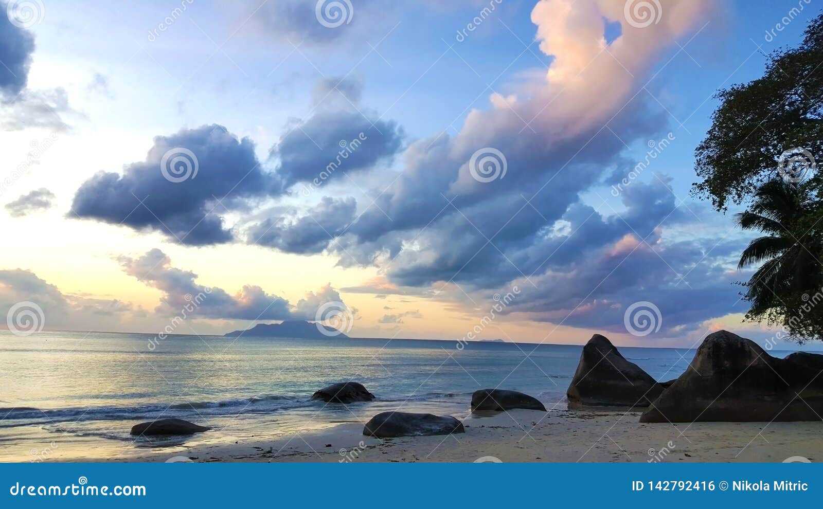 peaceful seychelles beach sunset with amazing sky and rocks.