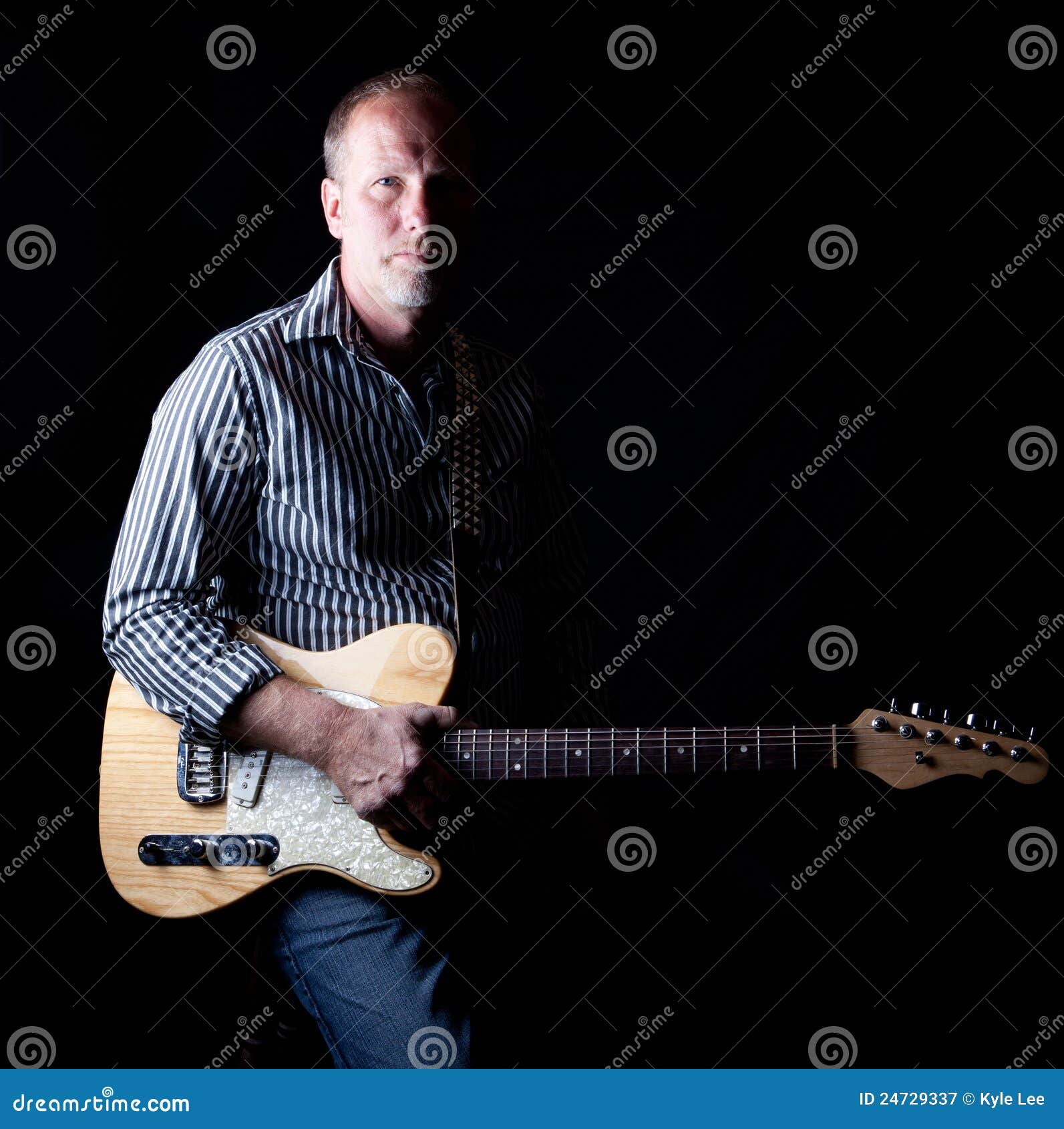shadow filled shot a rugged looking guitar player