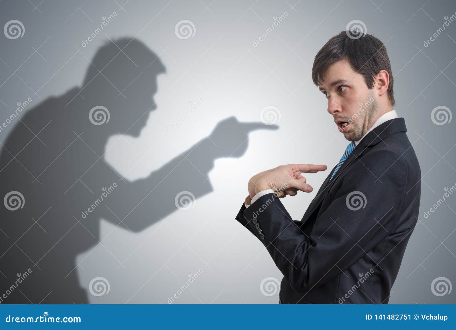 shadow of man is pointing and blaming businessman. conscience concept.