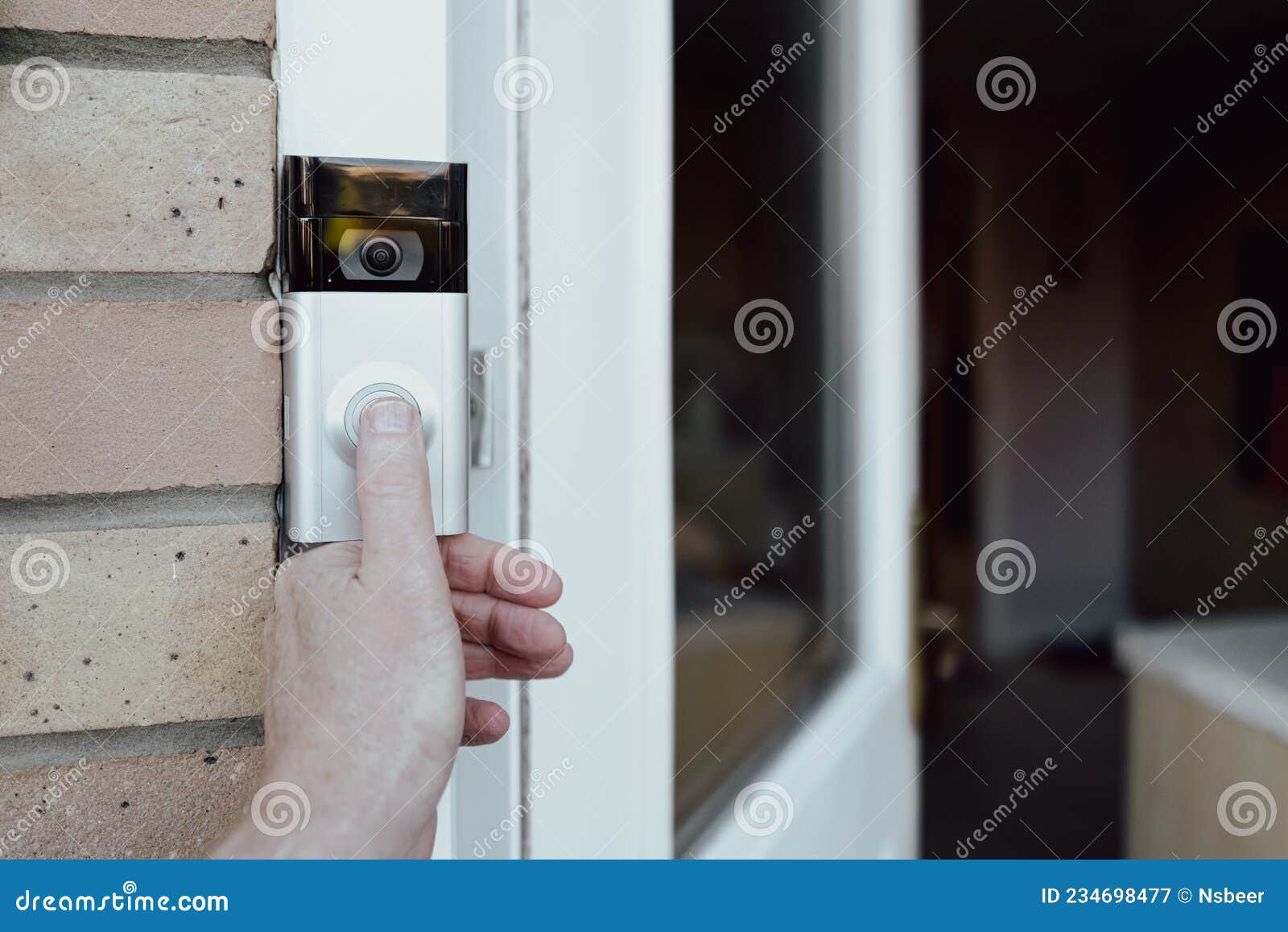 shallow focus of a homeowner seen testing a newly installed wifi smart doorbell.