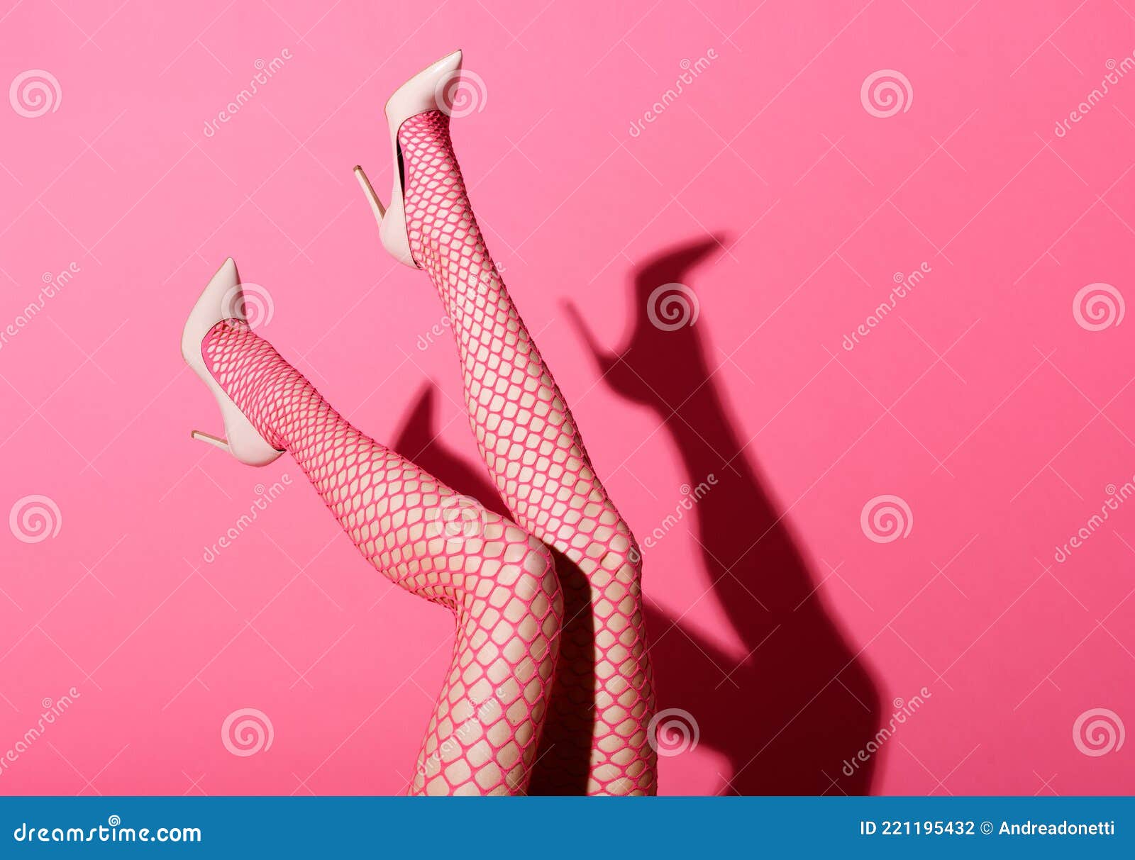 Shapely Legs of a Woman Wearing Pink Fishnet Stockings Stock Photo