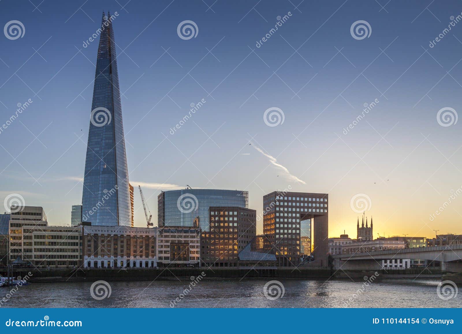 the shard and london bridge by river thames during sunset