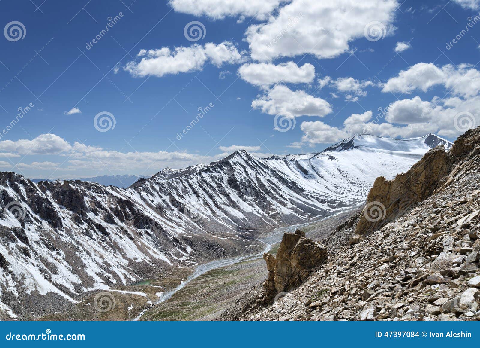 Sharp Snow Covered Mountain Ridge With River And Green Valley On Bottom