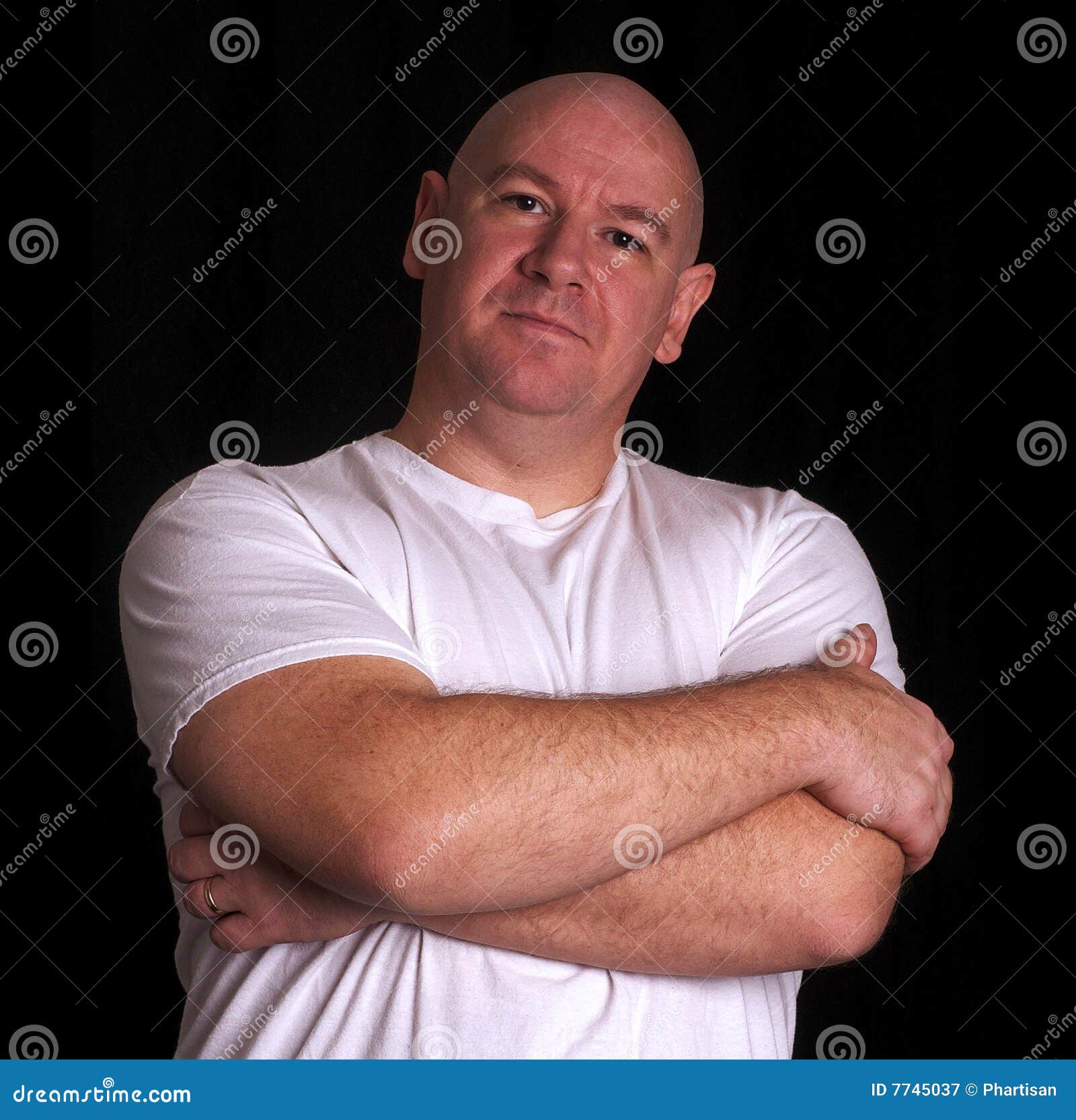 Shaved Head Male In A White Shirt With Tattooed Crossed Arms. Royalty