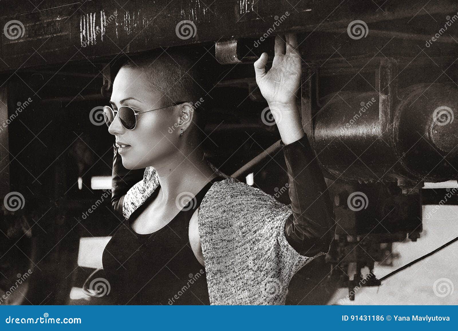 shaved-headed girl silhouette on the sunset scenery, desert view with train and rails