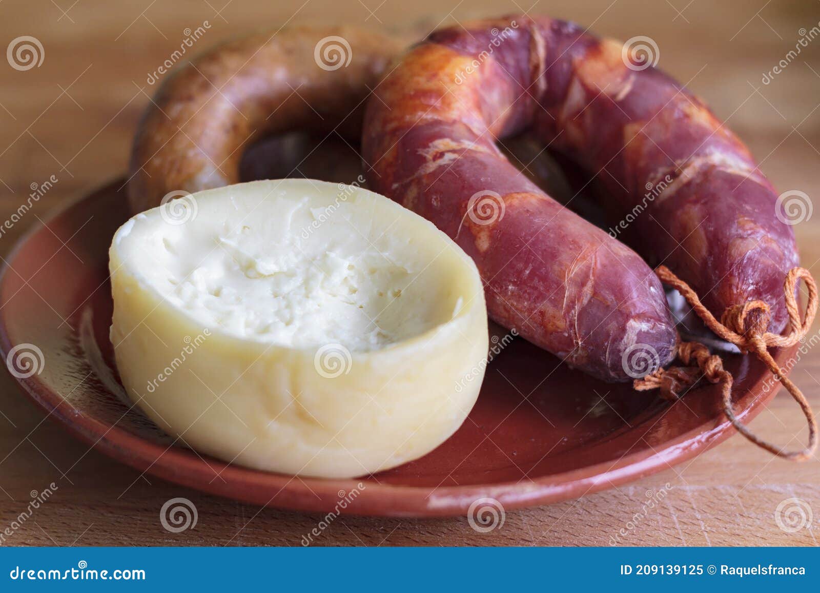 sheep's milk cheese from azeitao and portuguese smoked sausage on clay plate