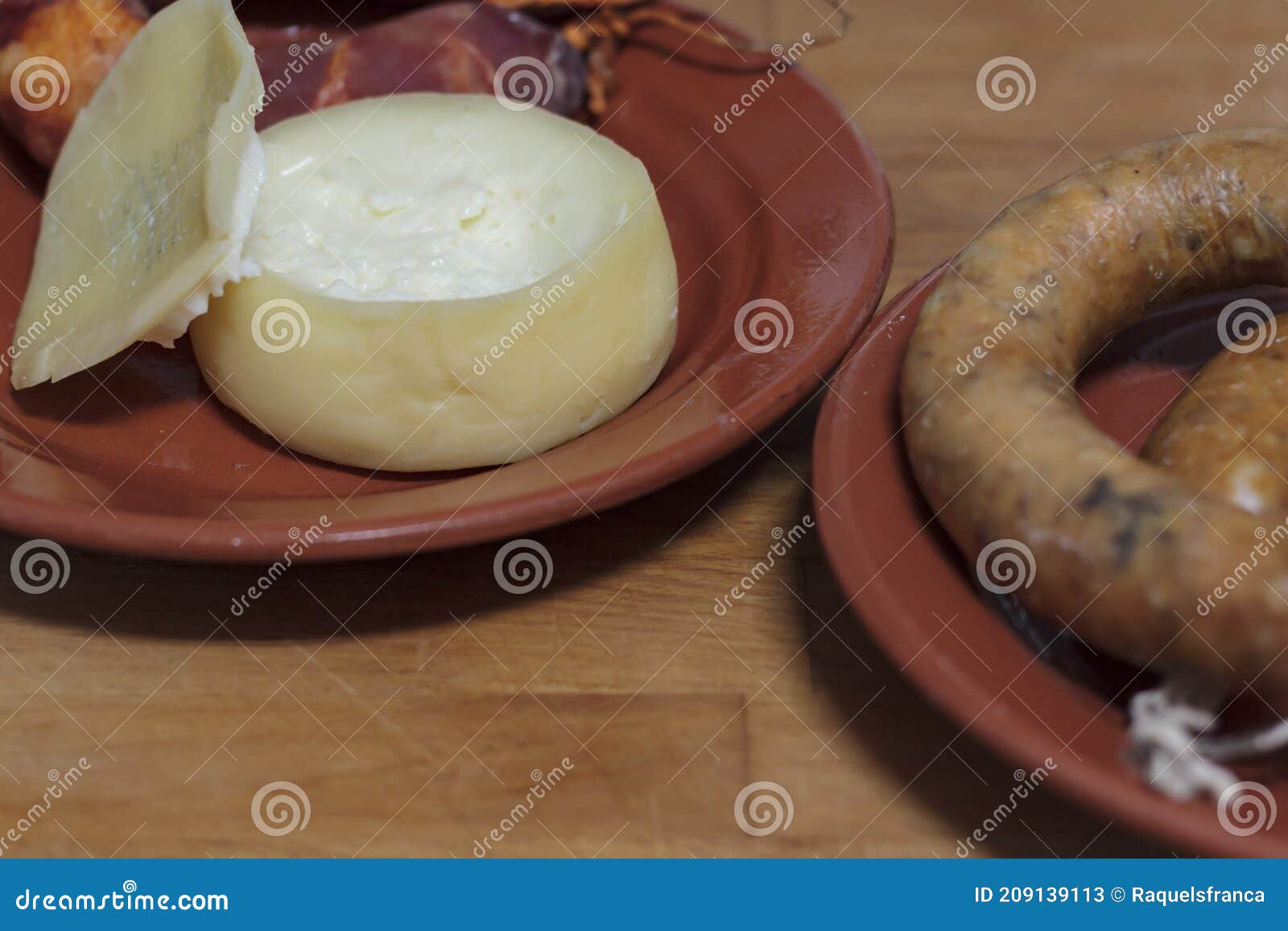 sheep's milk cheese and portuguese smoked sausage on clay plates