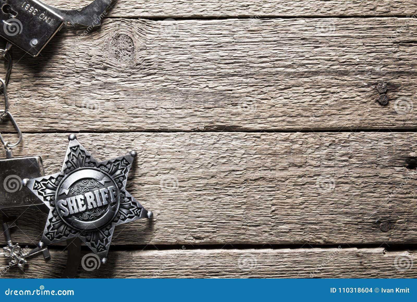 sheriff star and handcuffs on wooden table