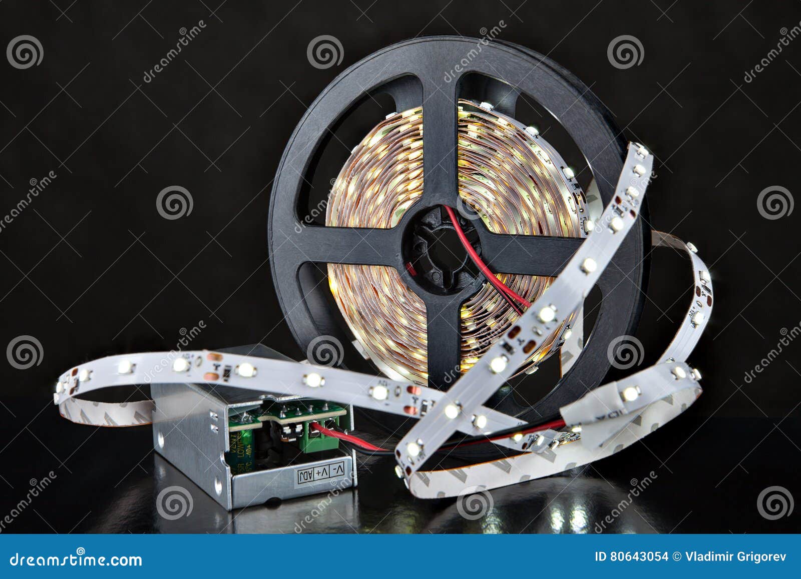 shining led light strip, and voltage adapter, on black background.