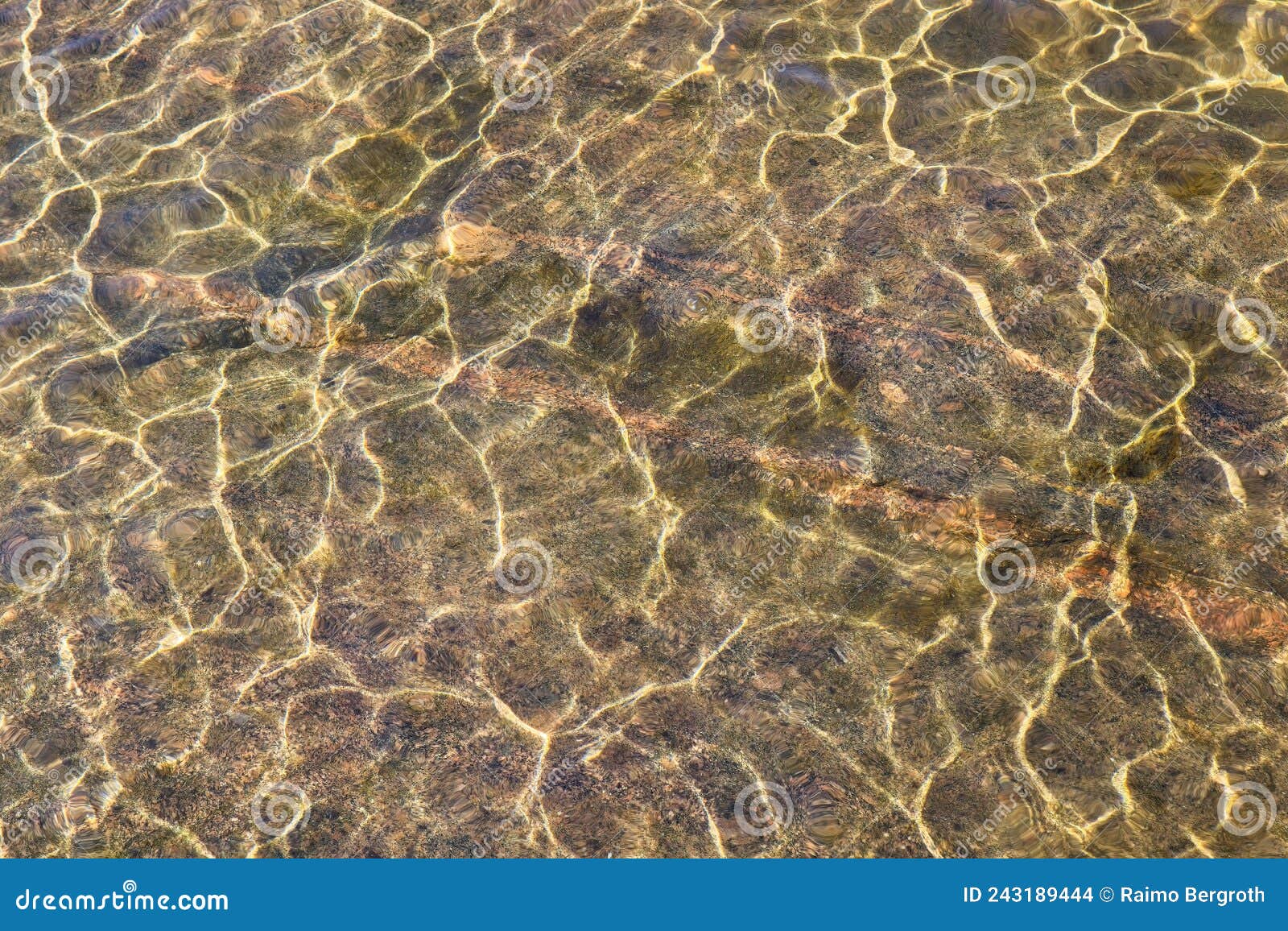 shining reflections of sun rays on rock bottom and ripples on the water surface.