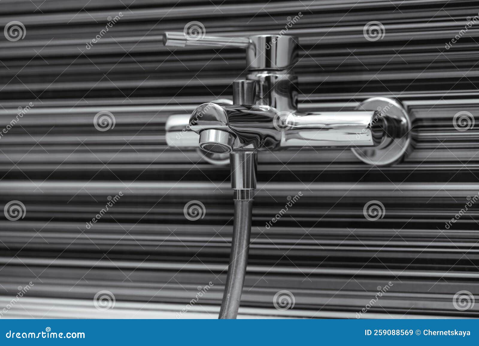 Shiny Bath Water Tap Installed on Black and White Wall Stock Image