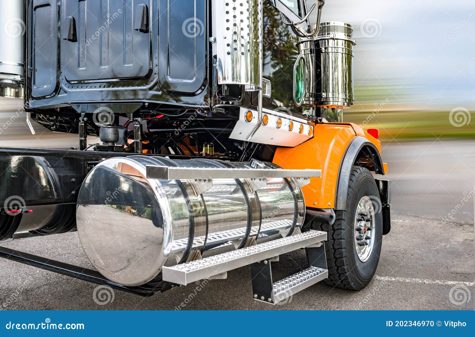 Shiny Big Rig Semi Truck Tractor in Black and Orange with Polisher Aluminum Fuel Tanks and Steps