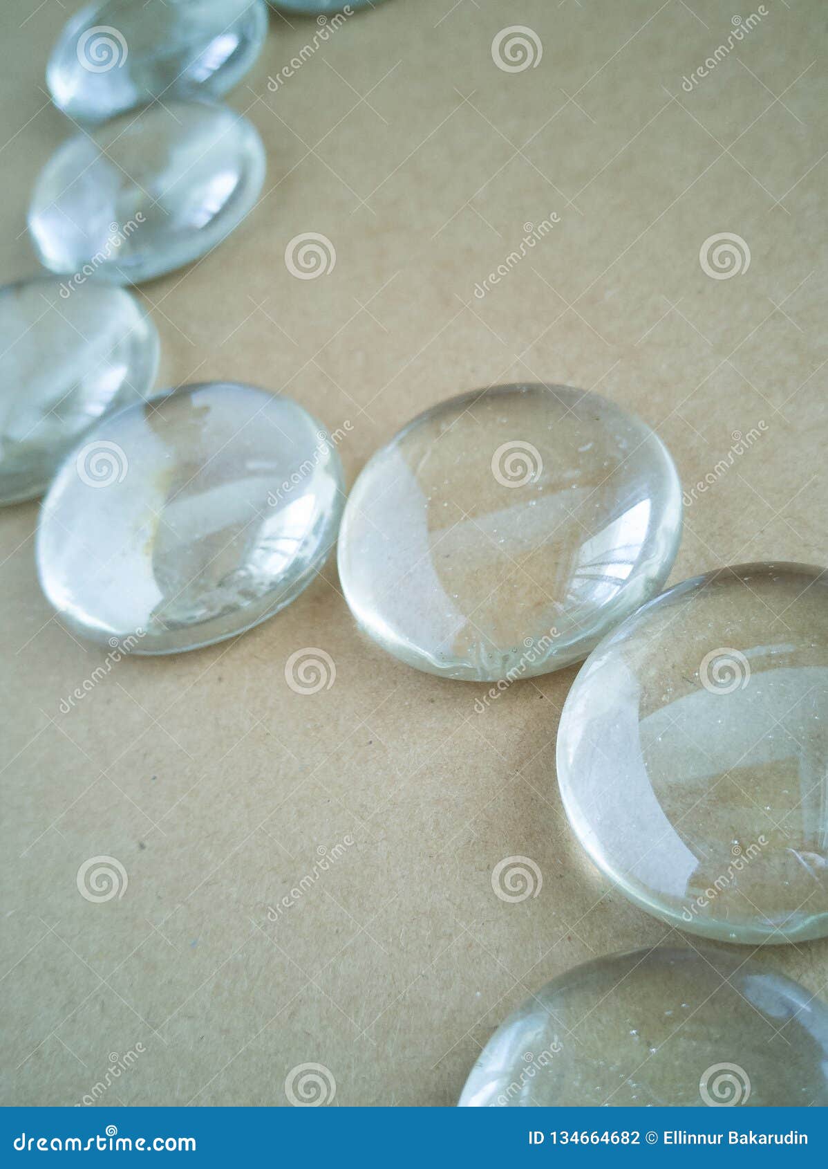 Clear Marbles with Light Reflections on a Brown Background. Stock Photo