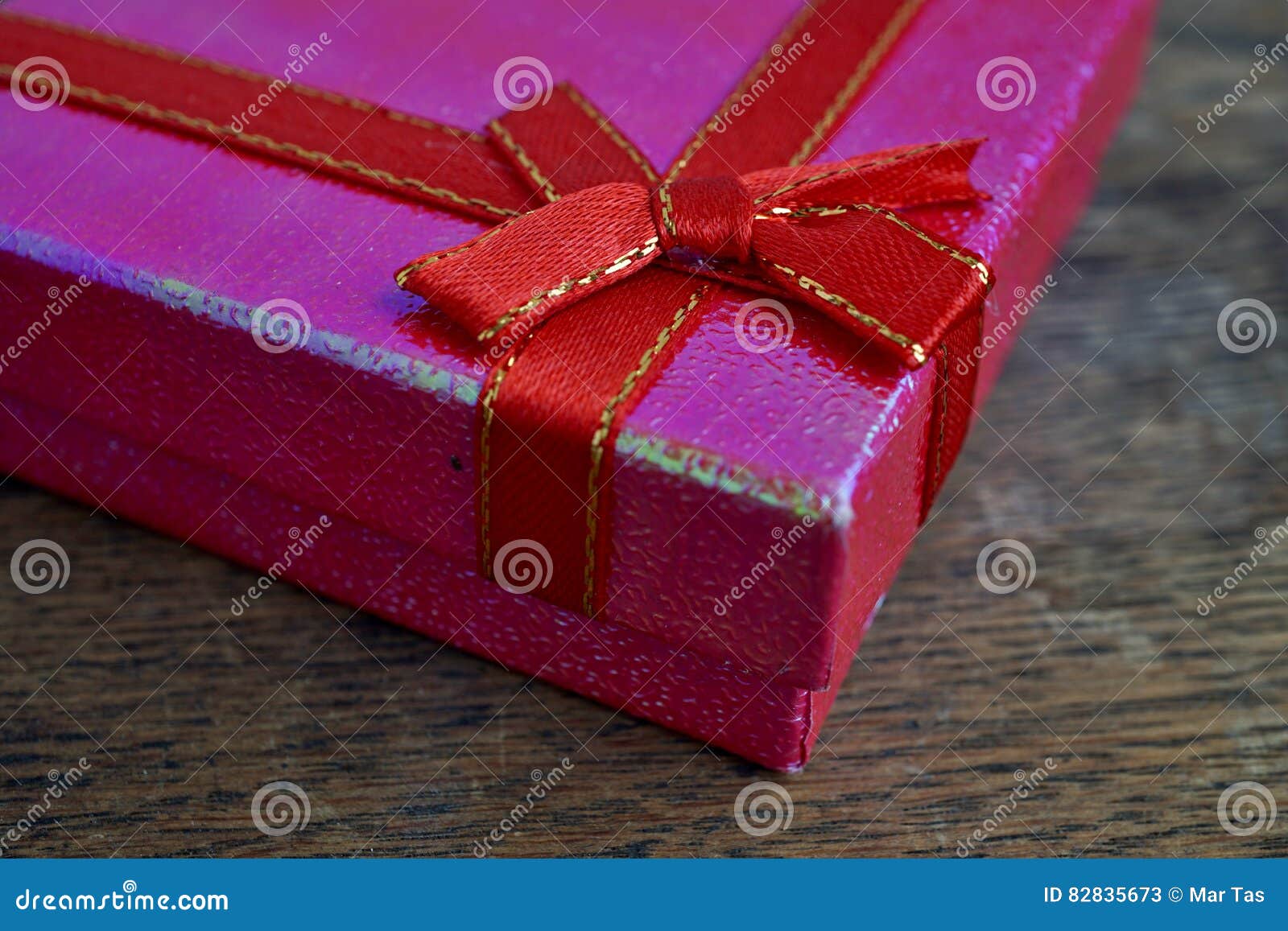 Shiny Closed Pink Gift Box with Red Ribbon and Golden Stitching on the ...