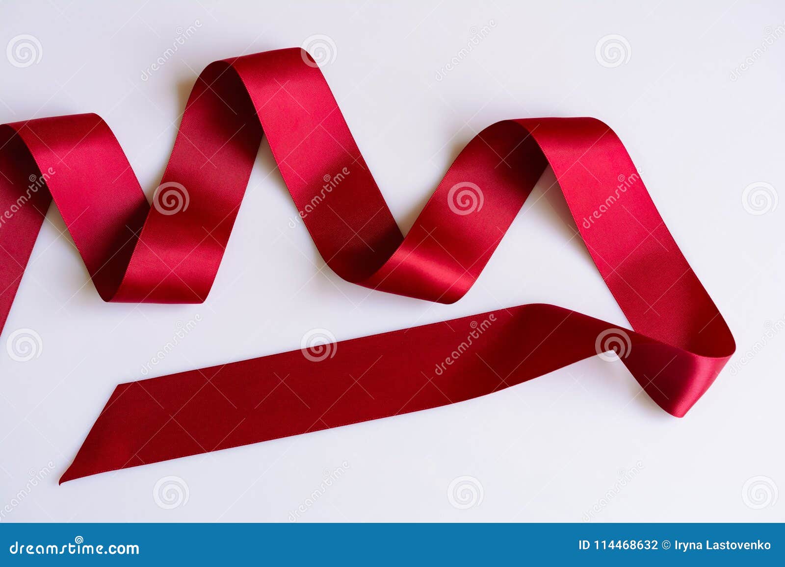 Shiny red satin ribbon on white background Stock Photo by