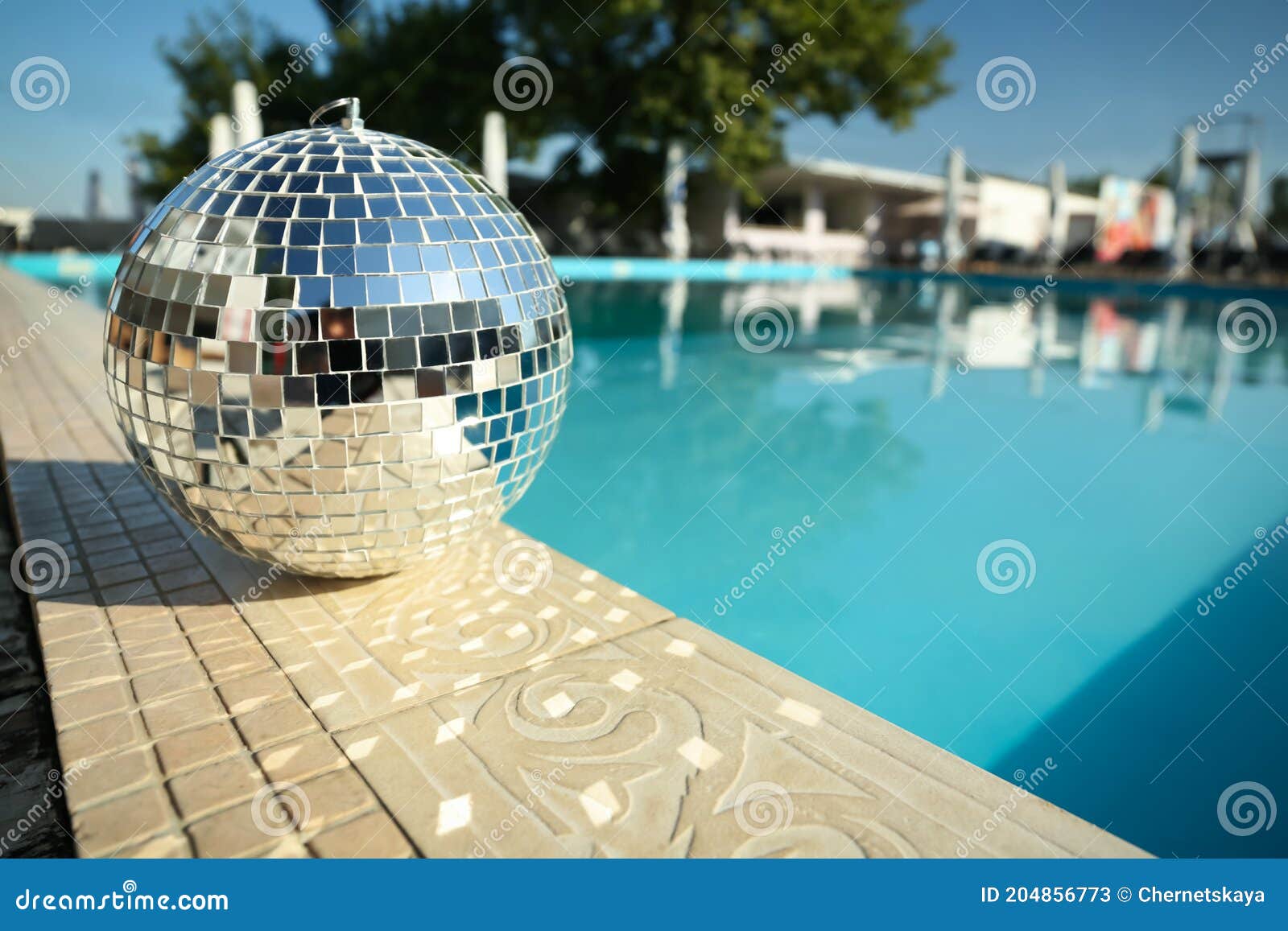 Shiny Disco Ball On Edge Of Swimming Pool Party Decor Stock Image