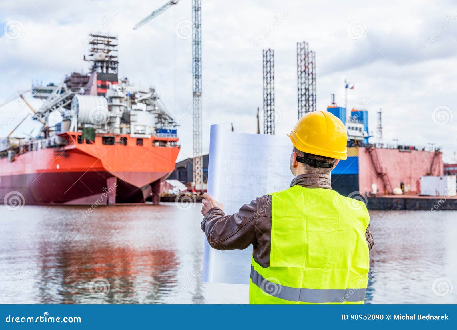 shipbuilding engineer checking documents at the dock side in a port.