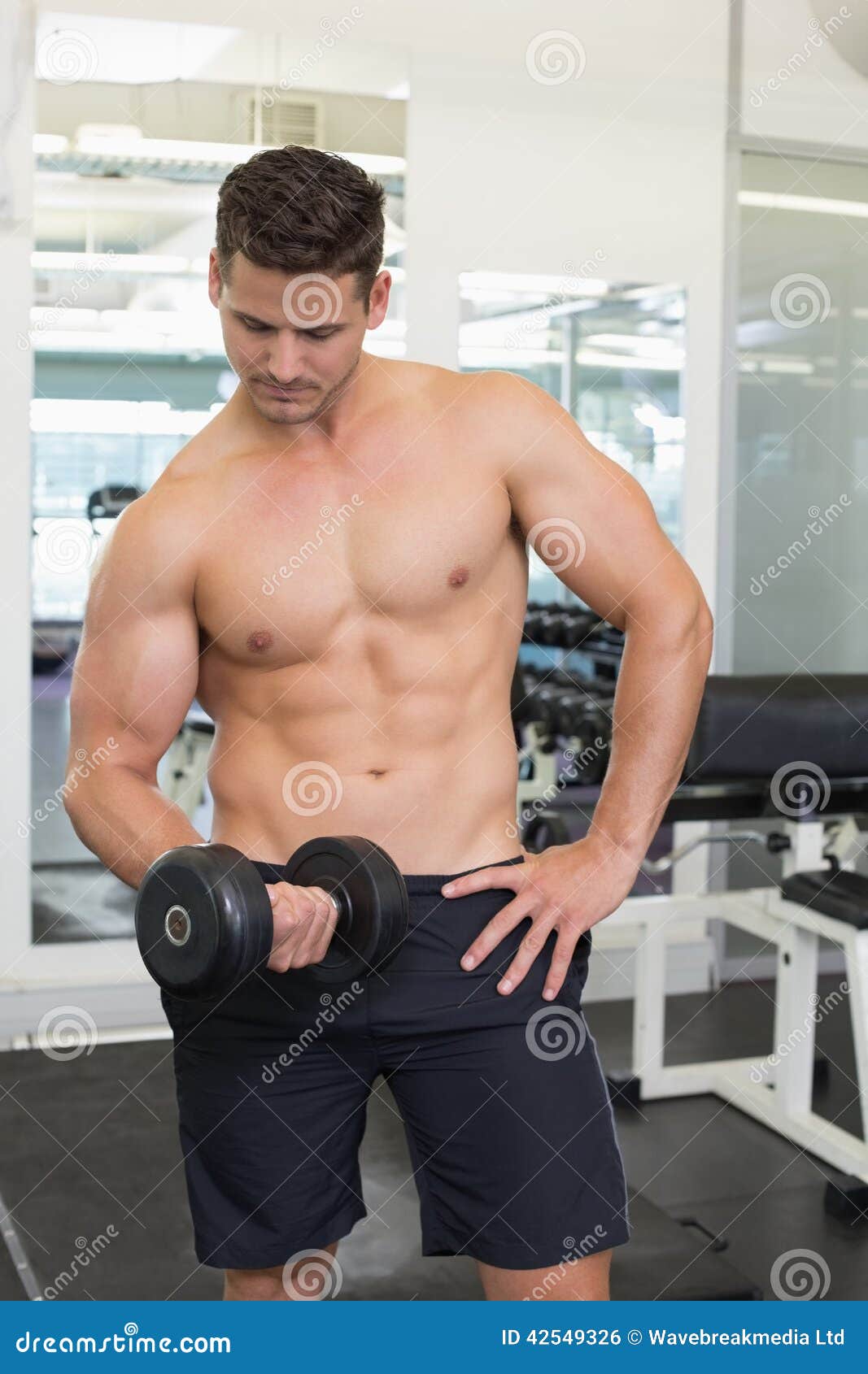 Shirtless Focused Bodybuilder Lifting Heavy Black Dumbbell Stock