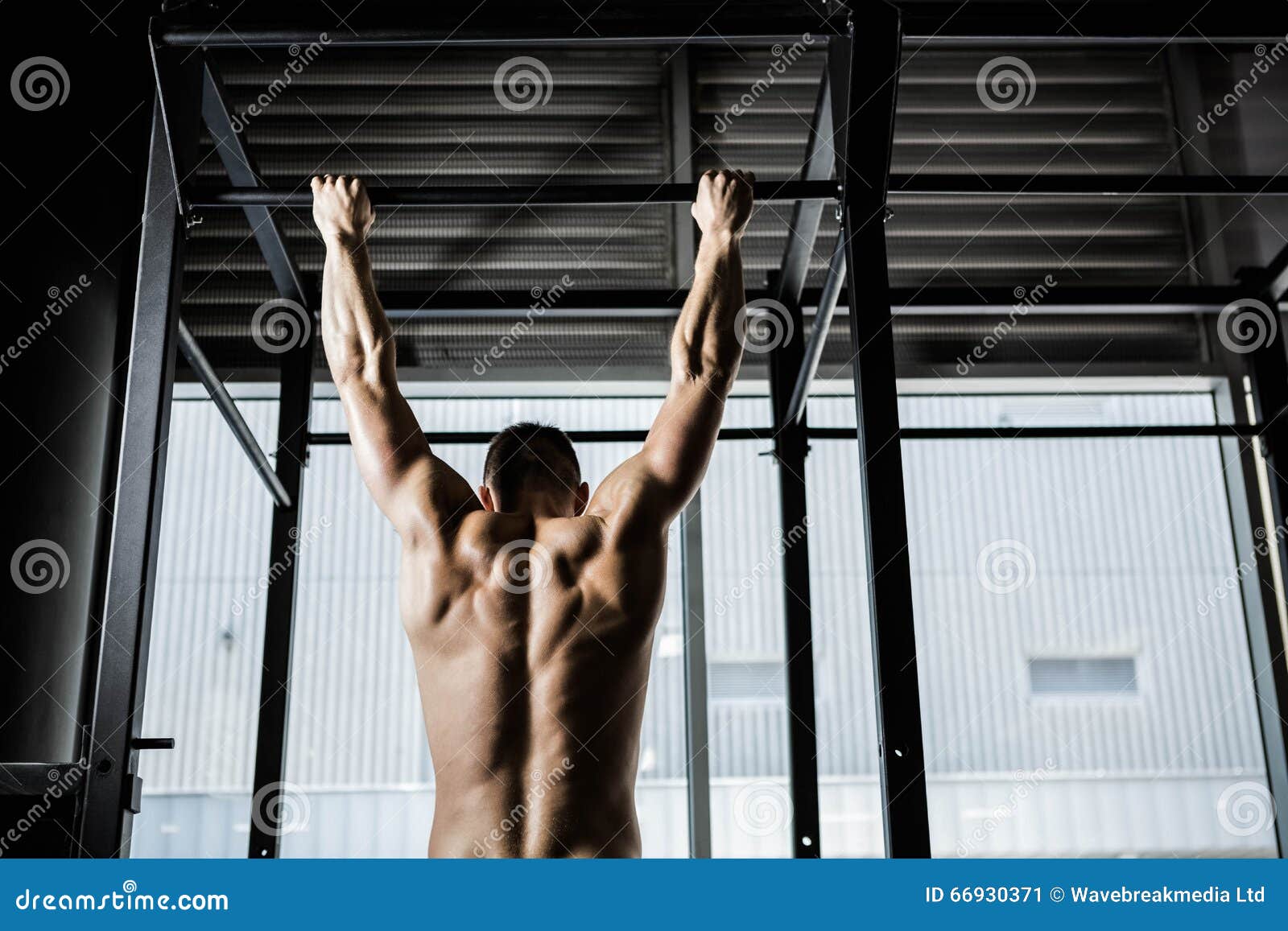 shirtless man doing pull up