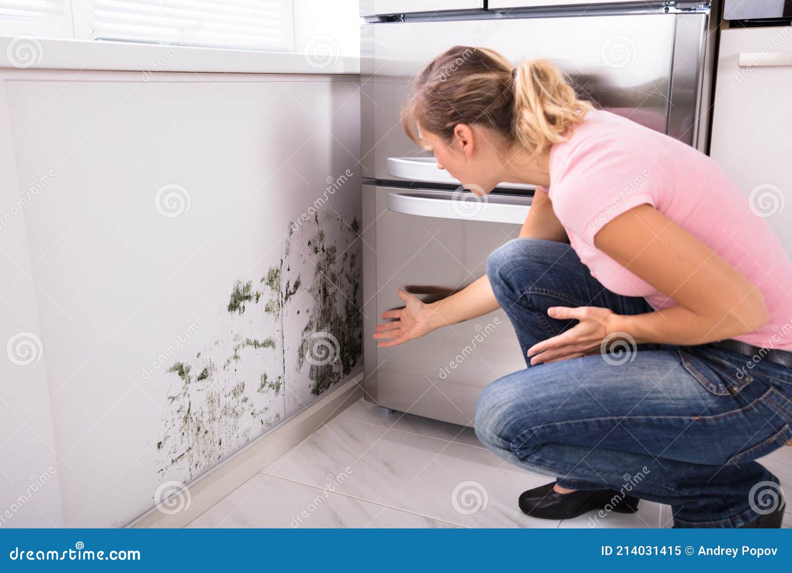 shocked woman looking at mold on wall