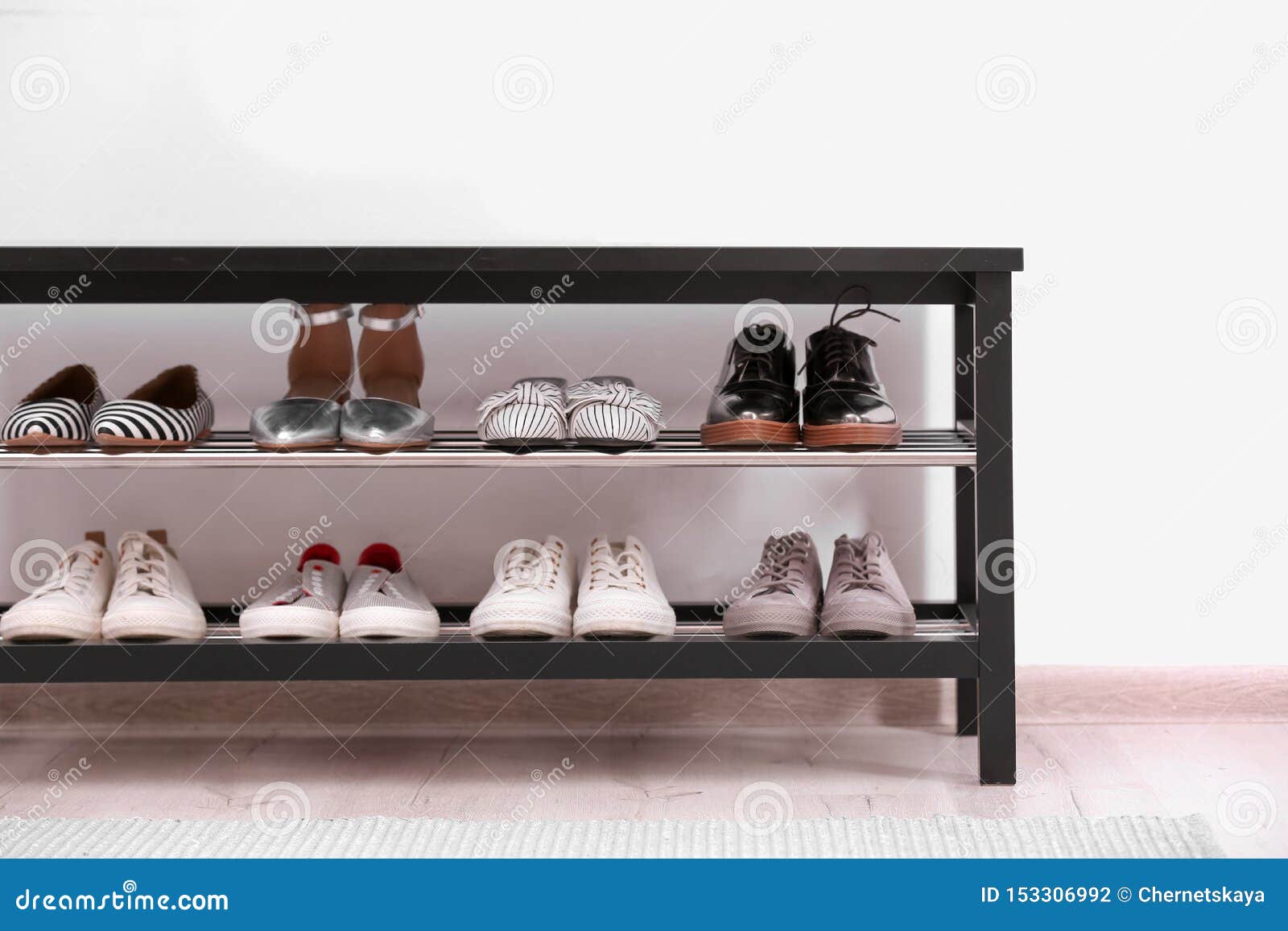Shoe Rack With Different Footwear Near White Wall Stock ...
