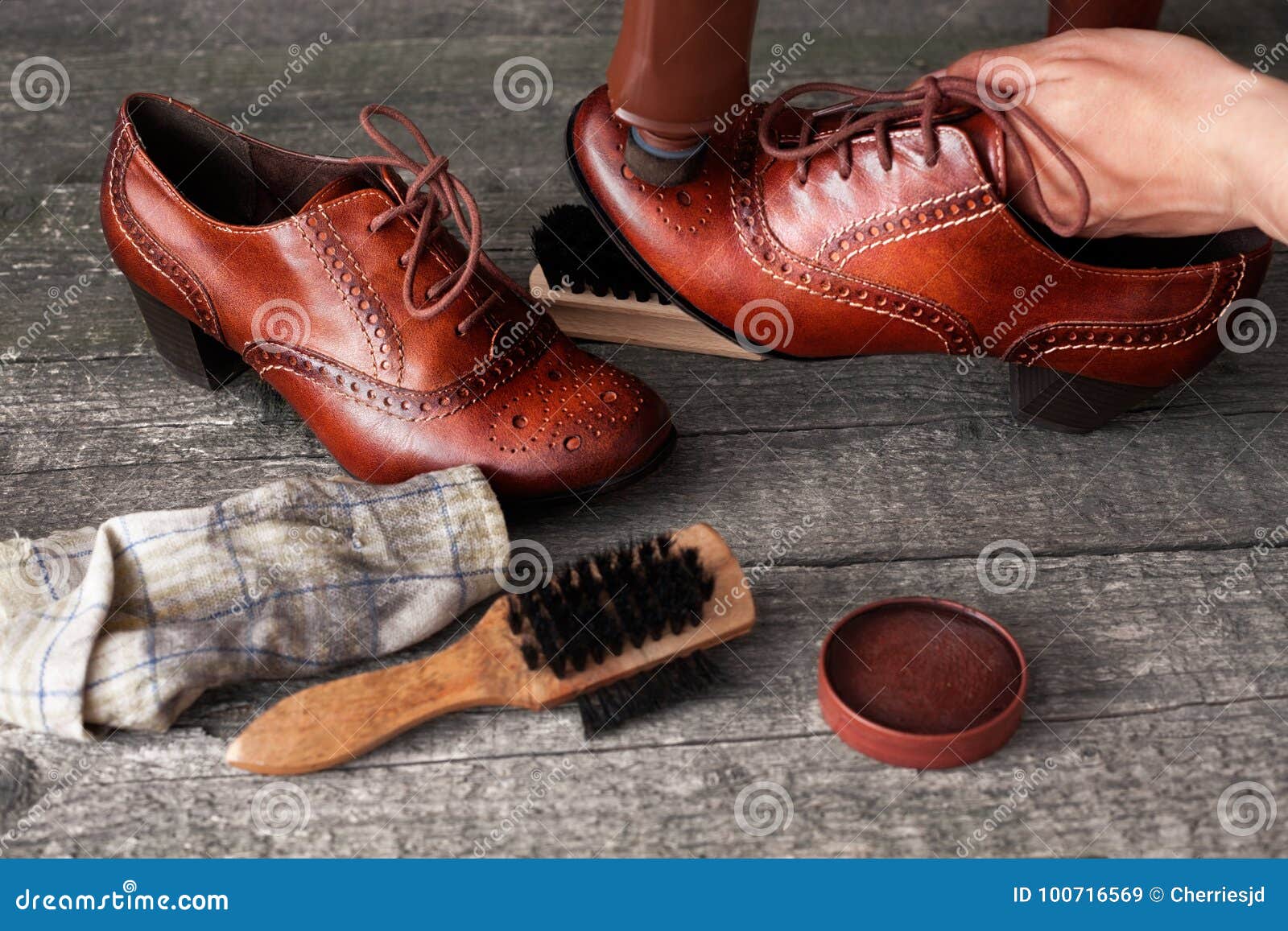 shoemaker applying shoe shiner on shoe