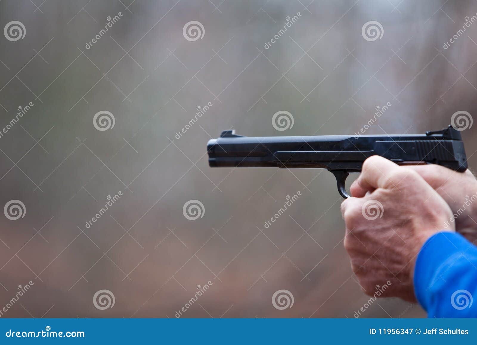 Shooting a Pistol. Man firing a pistol in the woods