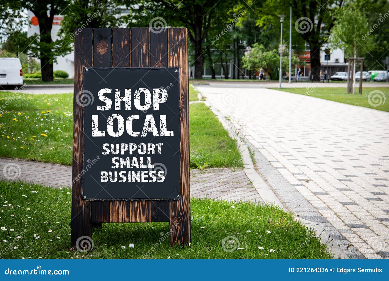 shop local. support small business. wooden billboard on the street, sunny day