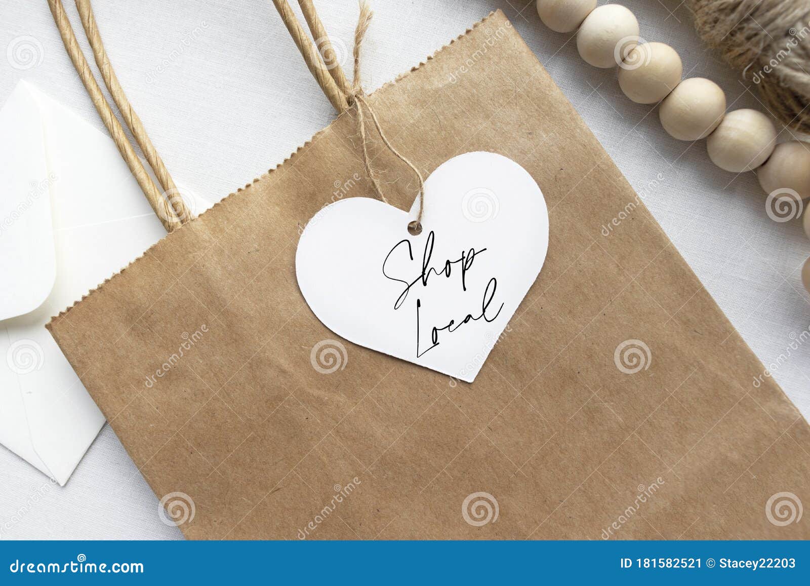 `shop local` text on a gift tag and brown paper bag