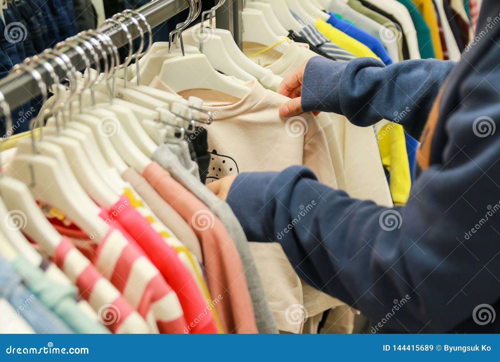 Shopping Concept - Choosing Clothes at Clothing Shop Stock Image ...