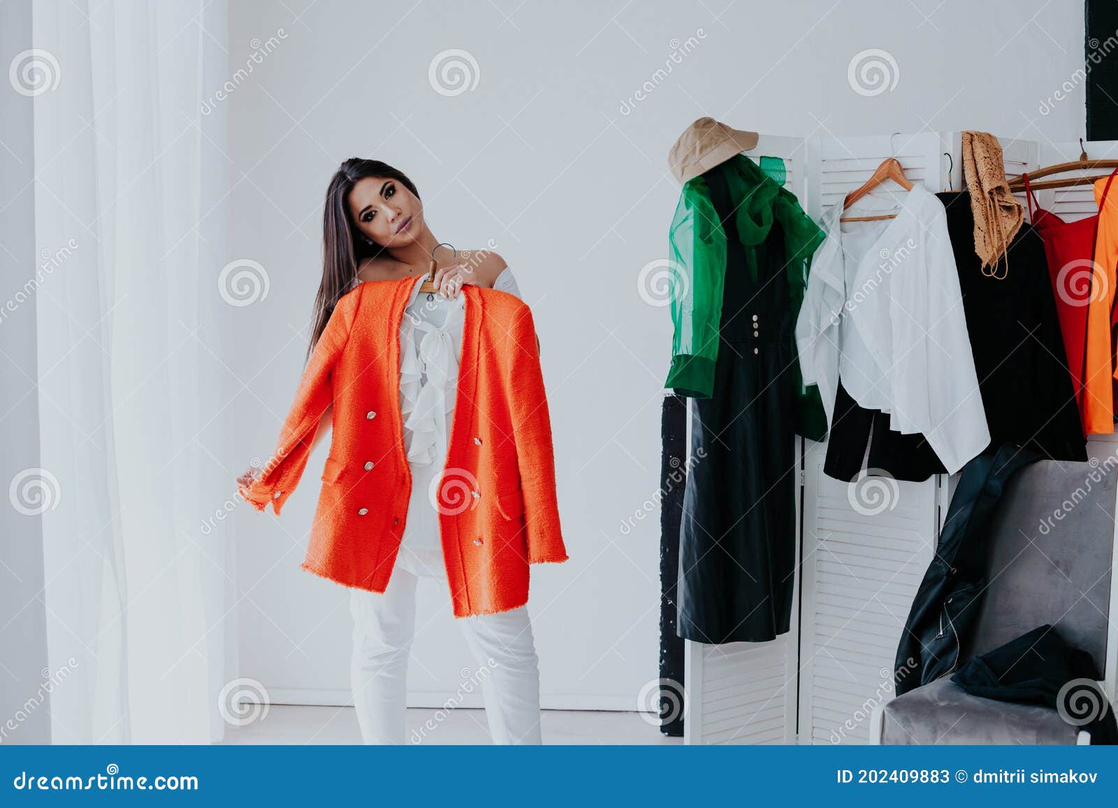 shopping woman trying clothes. woman choosing between summer dresses looking in mirror.