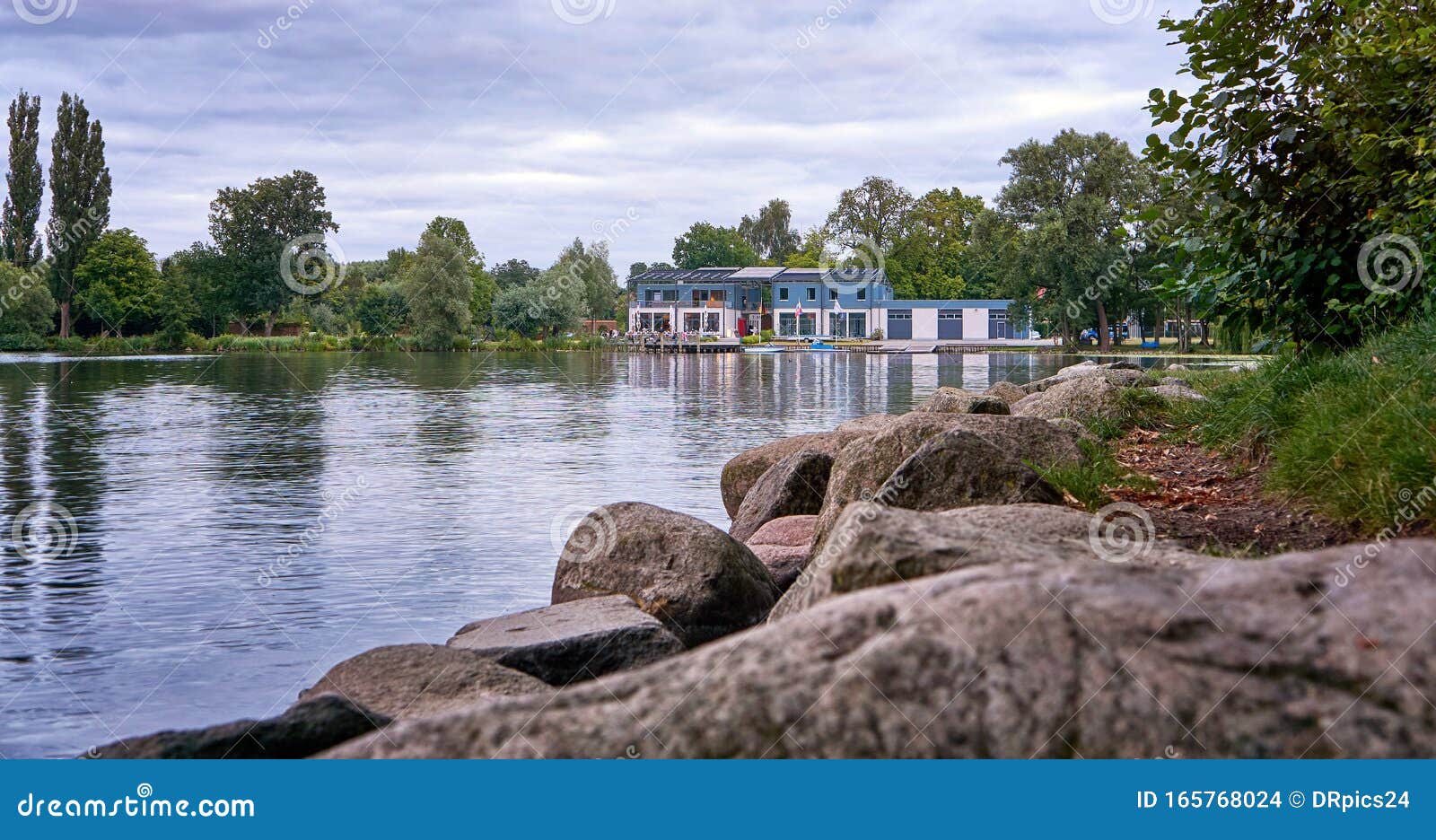shore with big stones at schwerin lake overlooking the restaurante rowing club. germany